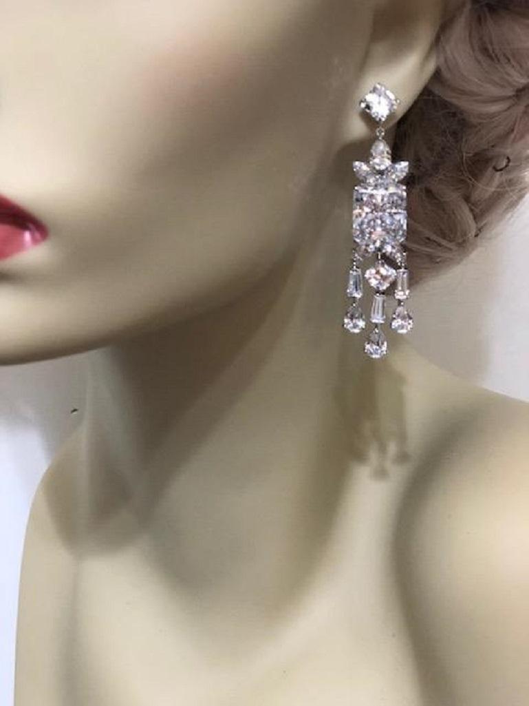 A pair of stunning faux synthetic diamond white cubic zirconia sterling earrings.
The intense realness of the stones are equivalent to 8 carats surrounded by bright white cubic zircons all set like the finest real diamond jewelry. Set in rhodium