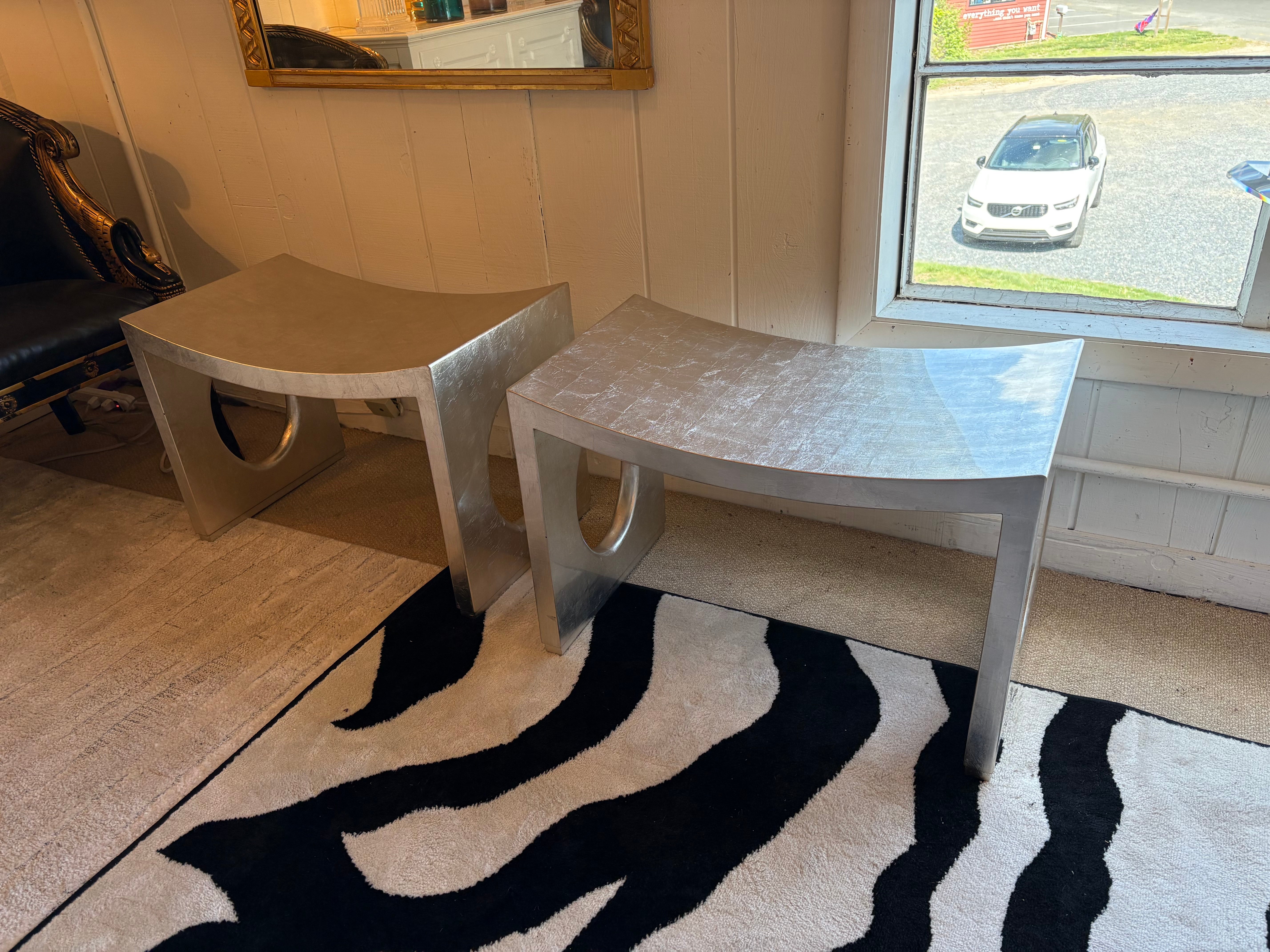 Paire de bancs contemporains chic et élégants, laqués à la feuille d'argent, avec des découpes ovales sur les côtés et une surface d'assise incurvée sculpturale.  La hauteur au sommet de l'écope est de 17