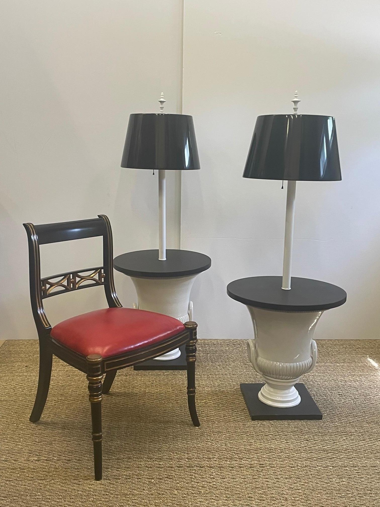 Chic Dorothy Draper style black and white floor lamps side tables having white ceramic urn shaped bases, black slate round table tops and square bases, and custom black tole shades.
Shades are 15.75 diameter at bottom 12