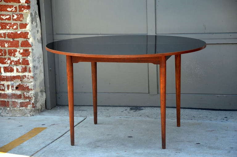 Elegante mesa escandinava de teca con tablero de laminado negro resistente. Muy bien construido y resistente.