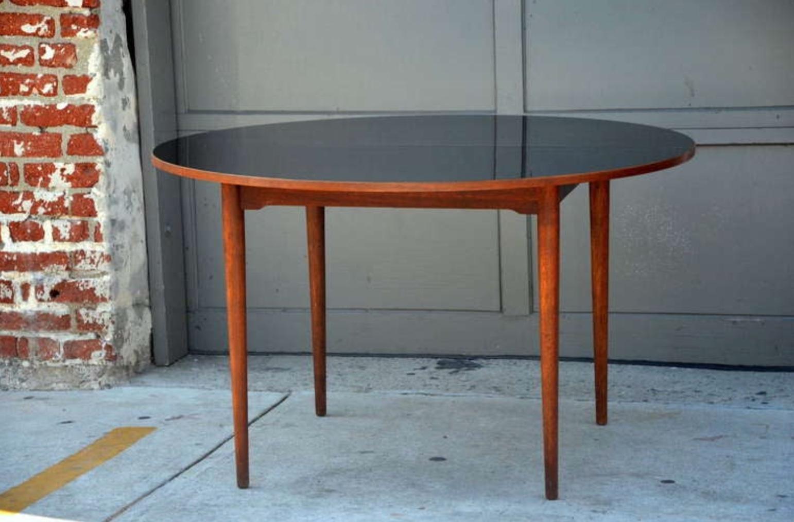 Chic Scandinavian teak table with durable black laminate top. Very well constructed and sturdy.