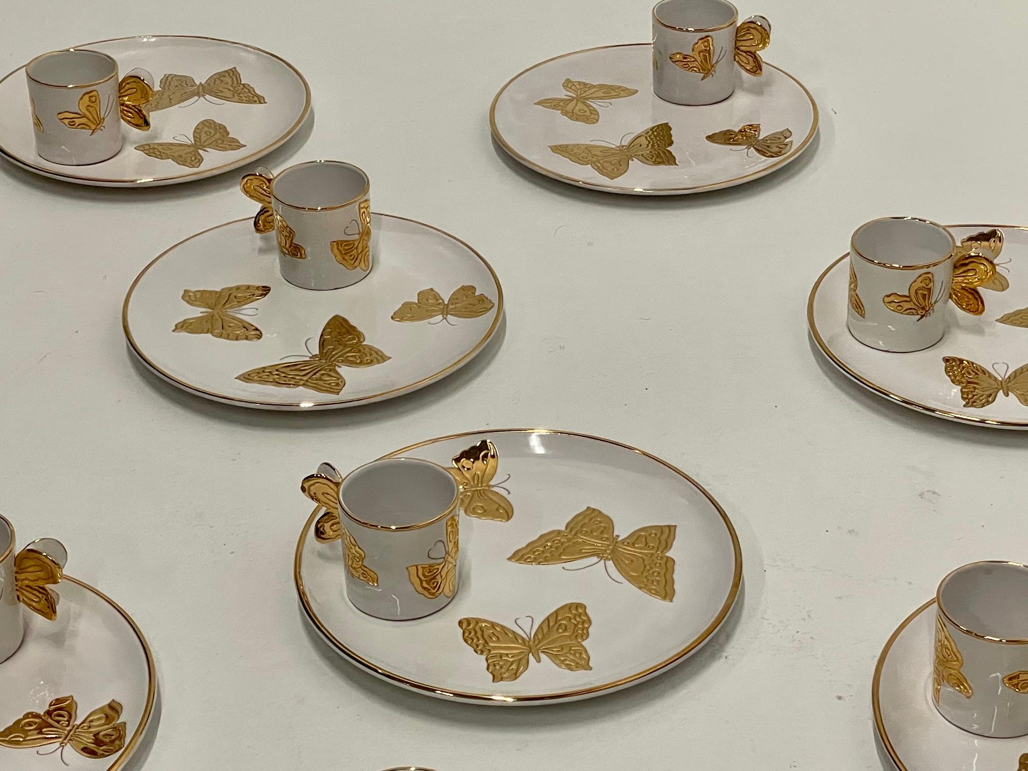 Marvelous set of 12 Carole Stupell Italian white pottery plates having gold butterfly adornments and matching cups that rest in slightly recessed circles. The cups have whimsical butterfly shaped handles.
Plates are 11