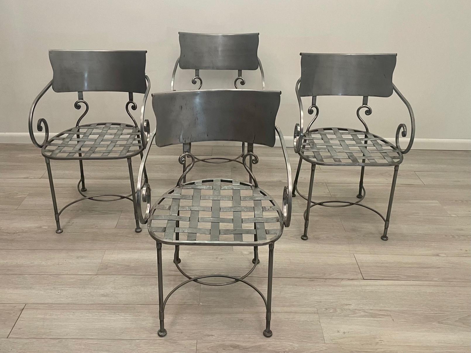 Chic set of 4 very stylish hand wrought iron armchairs for dining having a matte silver patina, curved back and elegant curlicue arms.