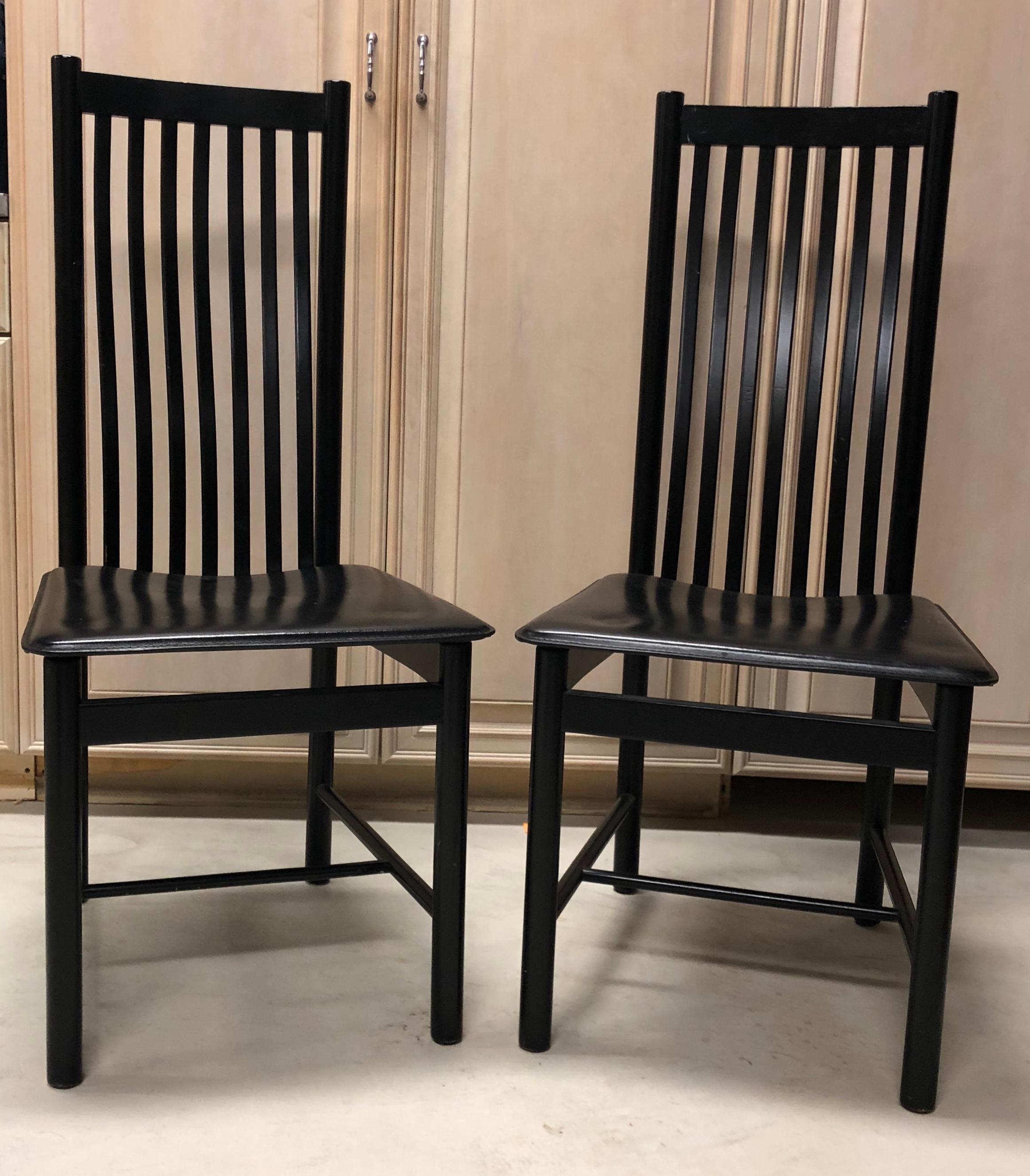 Chic set of 8 dining chairs in black lacquer with padded seat panels. The chairs are in very good condition and quite comfortable.