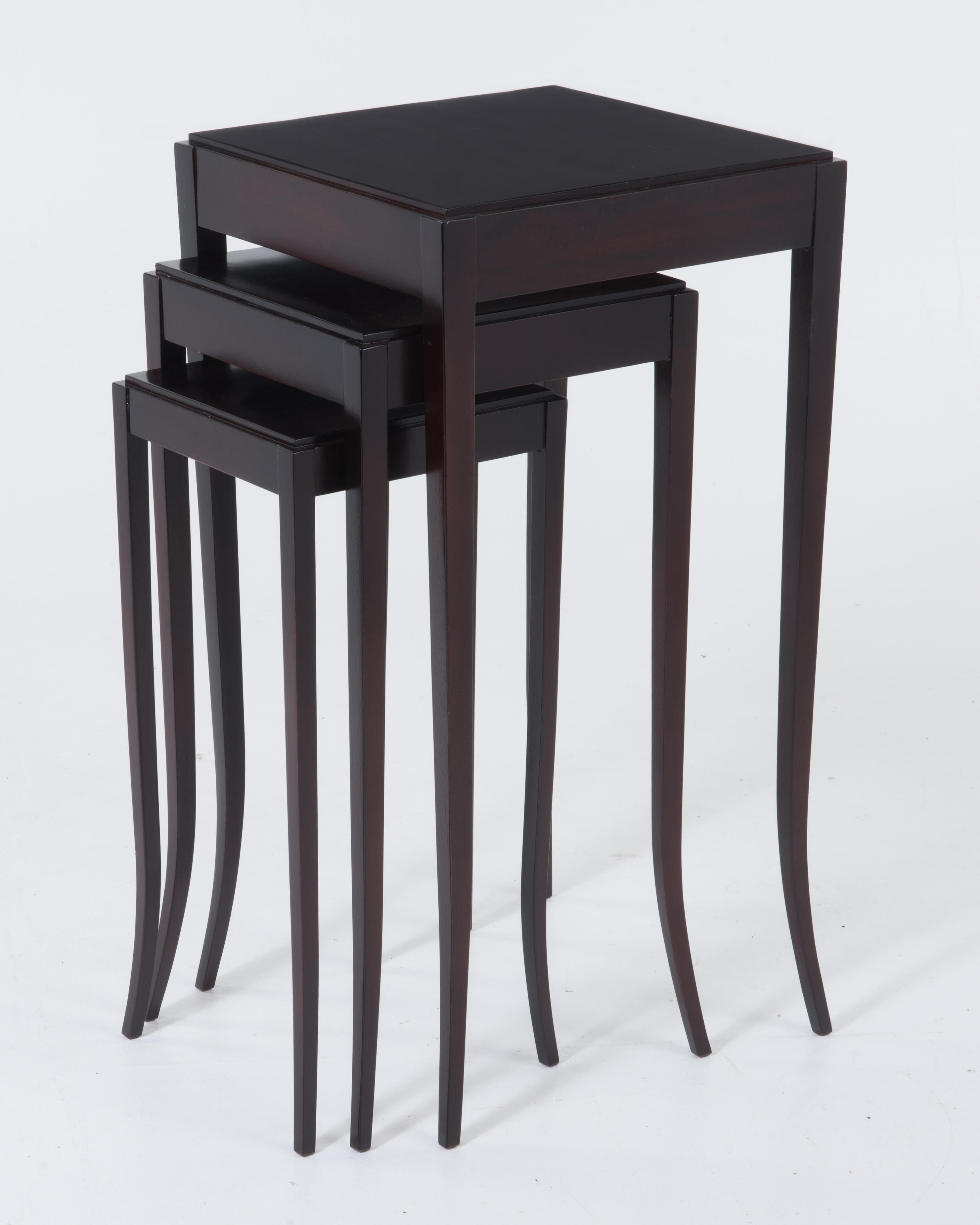 Very chic dark mahogany Java finish nesting tables by Barbara Barry having lovely saber shaped legs. The dimensions given are for the top table, and because the legs are saber shaped the top is smaller, 14 1/2 inches square. The middle table is 12