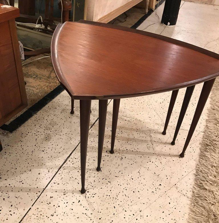 Chic set of 3 walnut triangular shaped Danish nesting tables with elegant tapered legs. Tables are of graduated sizes and fit neatly inside the other.
 