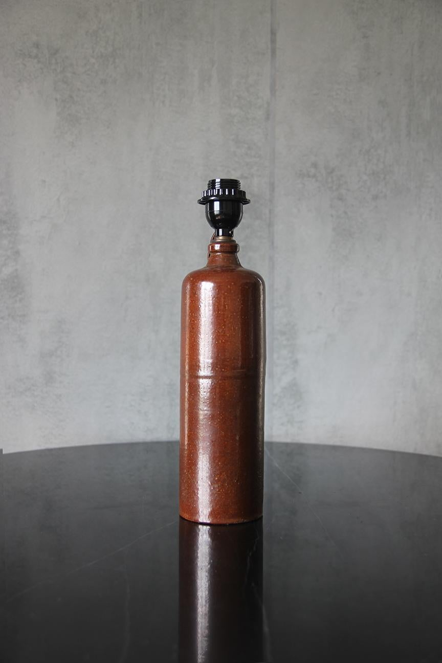 Vintage Stoneware Gin Bottle transformed into a Chic table lamp. 
Chic and Understated.
It has been professionally rewired with 3-way switch and twist cord. 

Dimensions listed is the overall dimensions of the lamp with the shade. 

Lamp with no