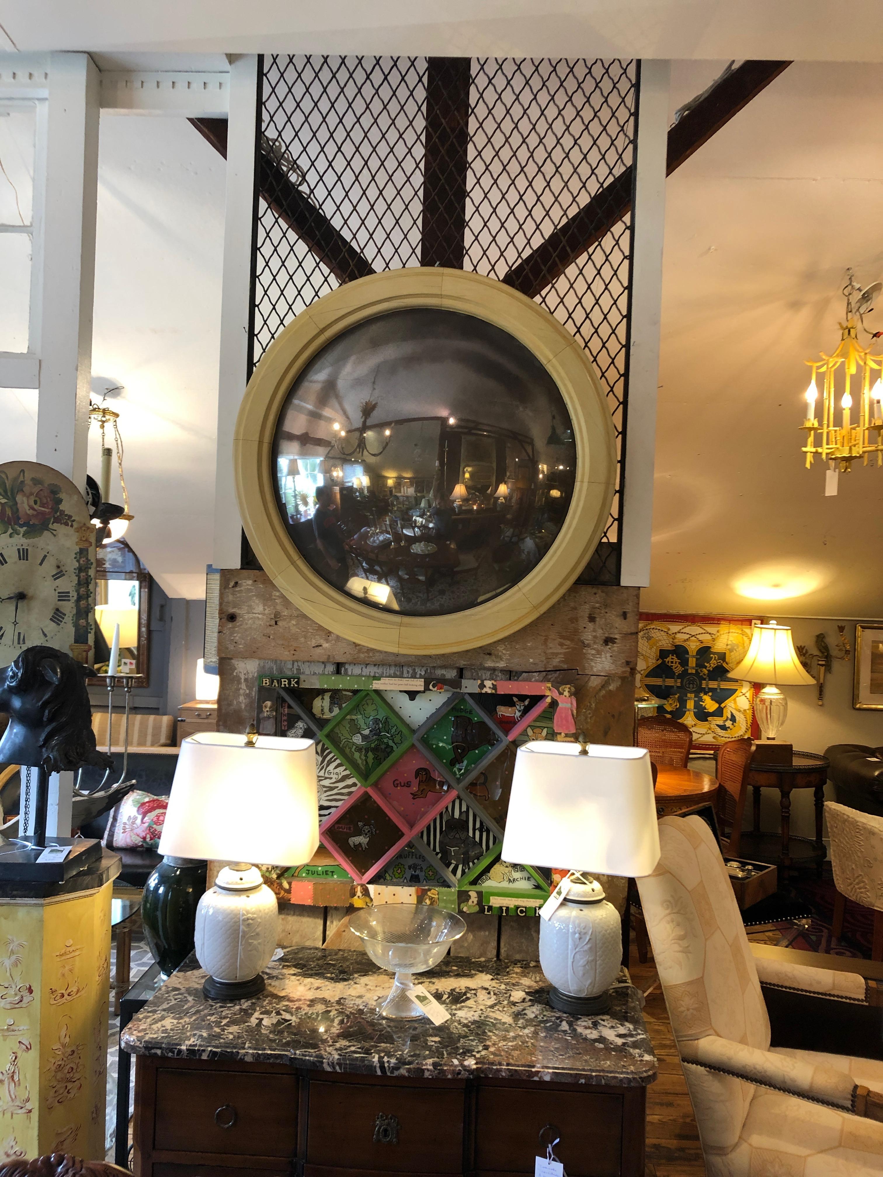 An incredibly chic 19th century French round convex bullseye mirror having faux ivory painted frame and fabulous ghosted aged mirror.