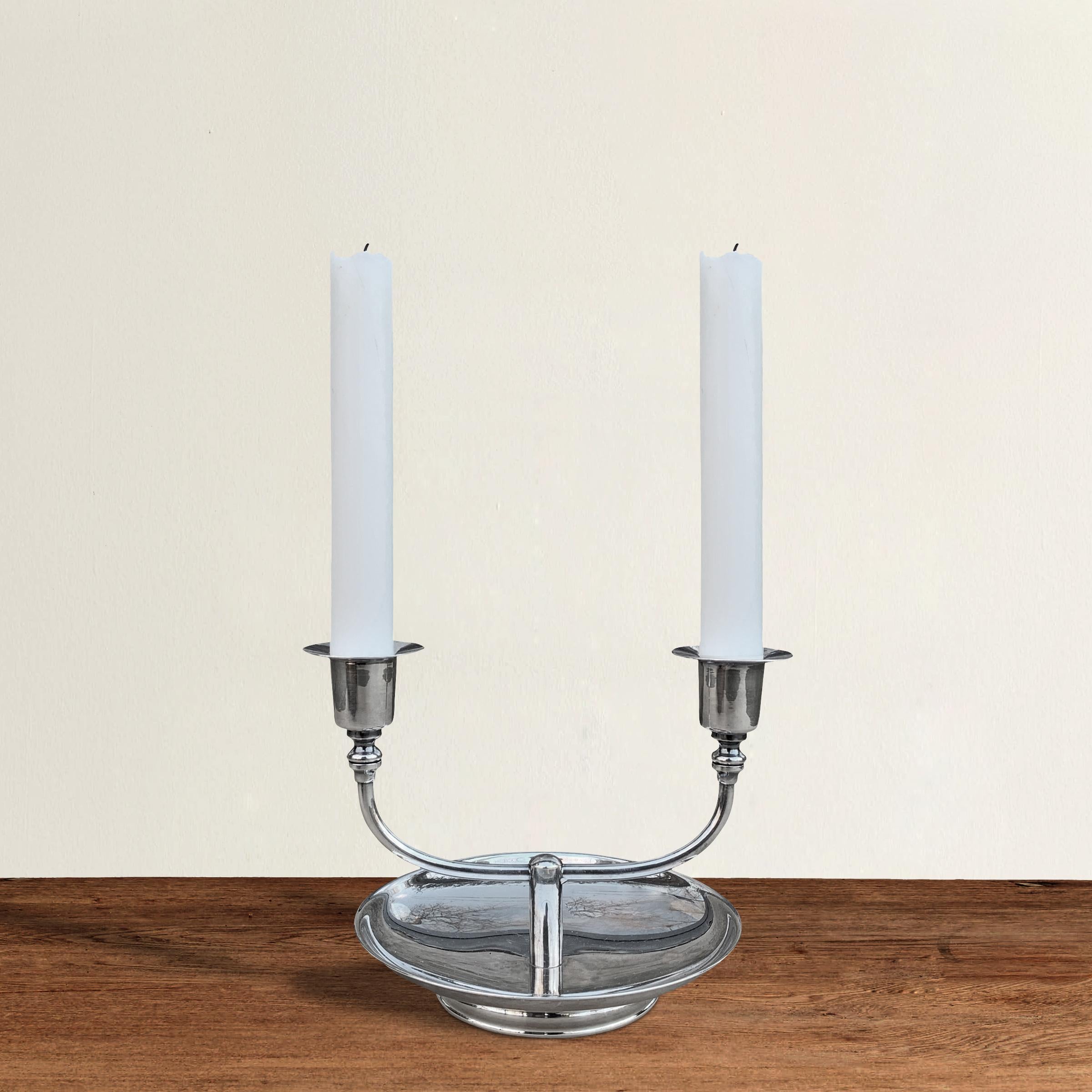 A chic vintage American silver-plate double candlestick with a convex footed base and two arms, each with simple candle cups.