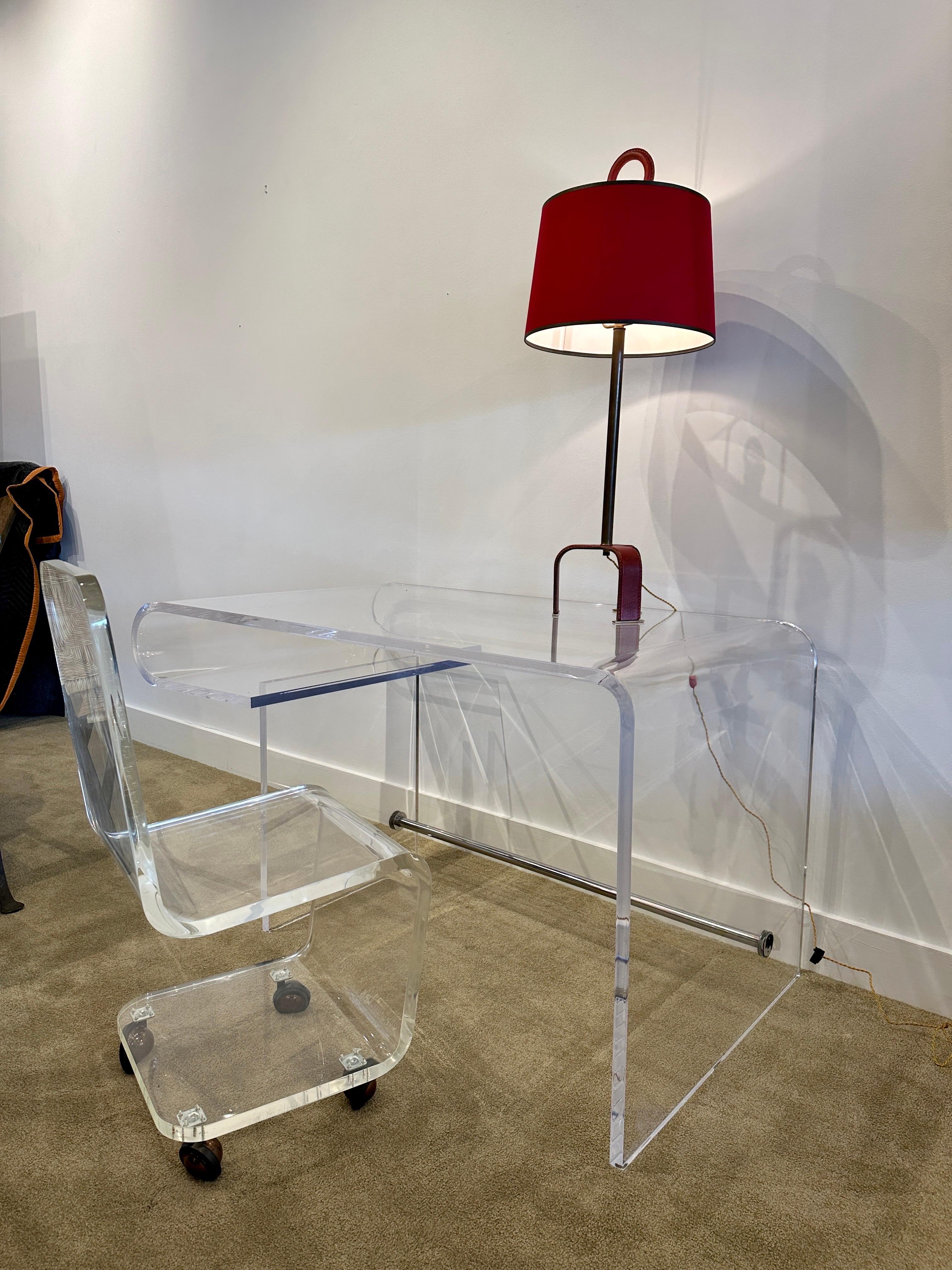 This sexy and unique curved Lucite desk with a lower tier for storage. Chrome stretcher to base provides additional stability and heft.  THIS ITEM IS LOCATED AND WILL SHIP FROM OUR MIAMI, FLORIDA SHOWROOM.