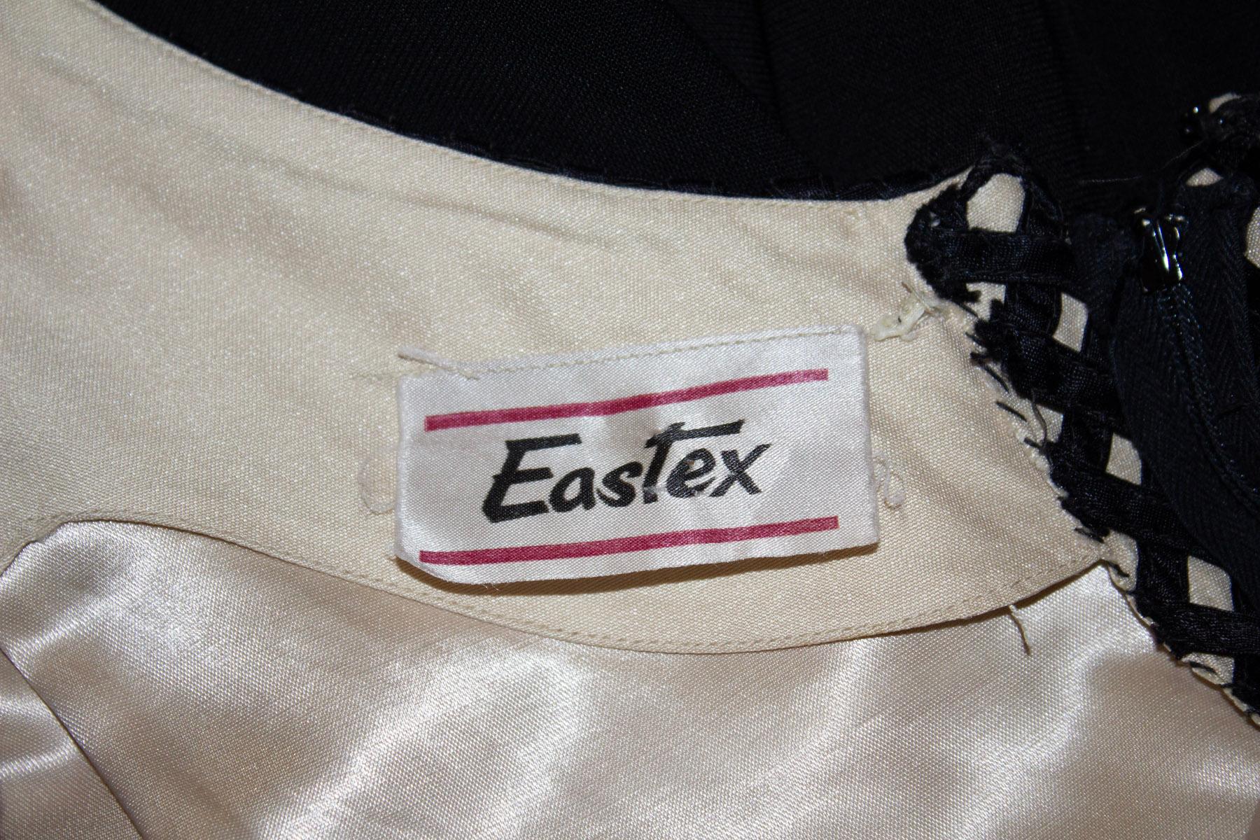A headturning vintage evening gown by Eastex. The dress has attractive lattice like detail on the upper area with a black skirt.  with an 11  '' slit at the back. 
Measurements: Bust 38'', waist 26'', length 53''