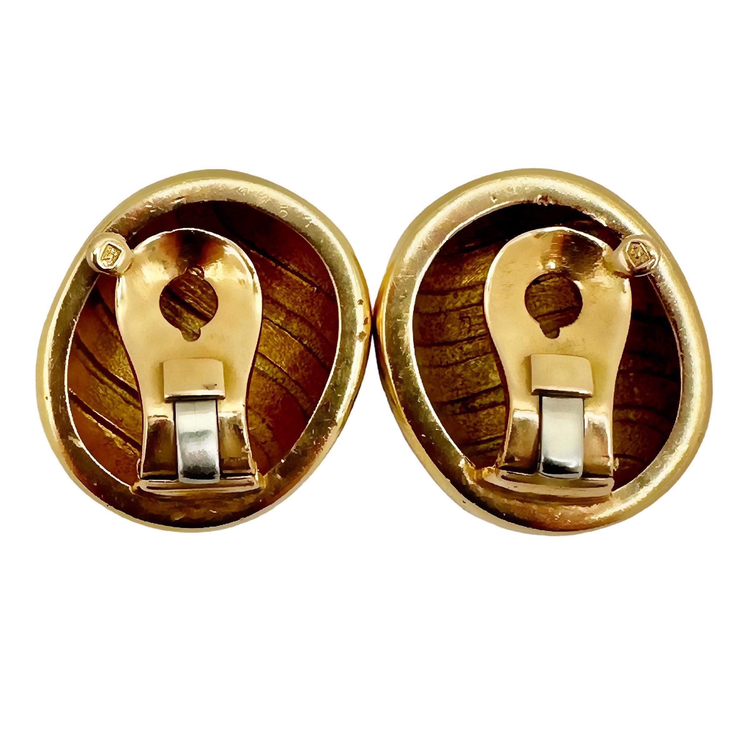 This striking pair of 18K yellow gold French Cartier Bombe earrings are simple in design and yet are visually enchanting. Five undulating bands of black enamel on each create a sense of motion. Measures 1 inch in length by 7/8 inch in width.  The