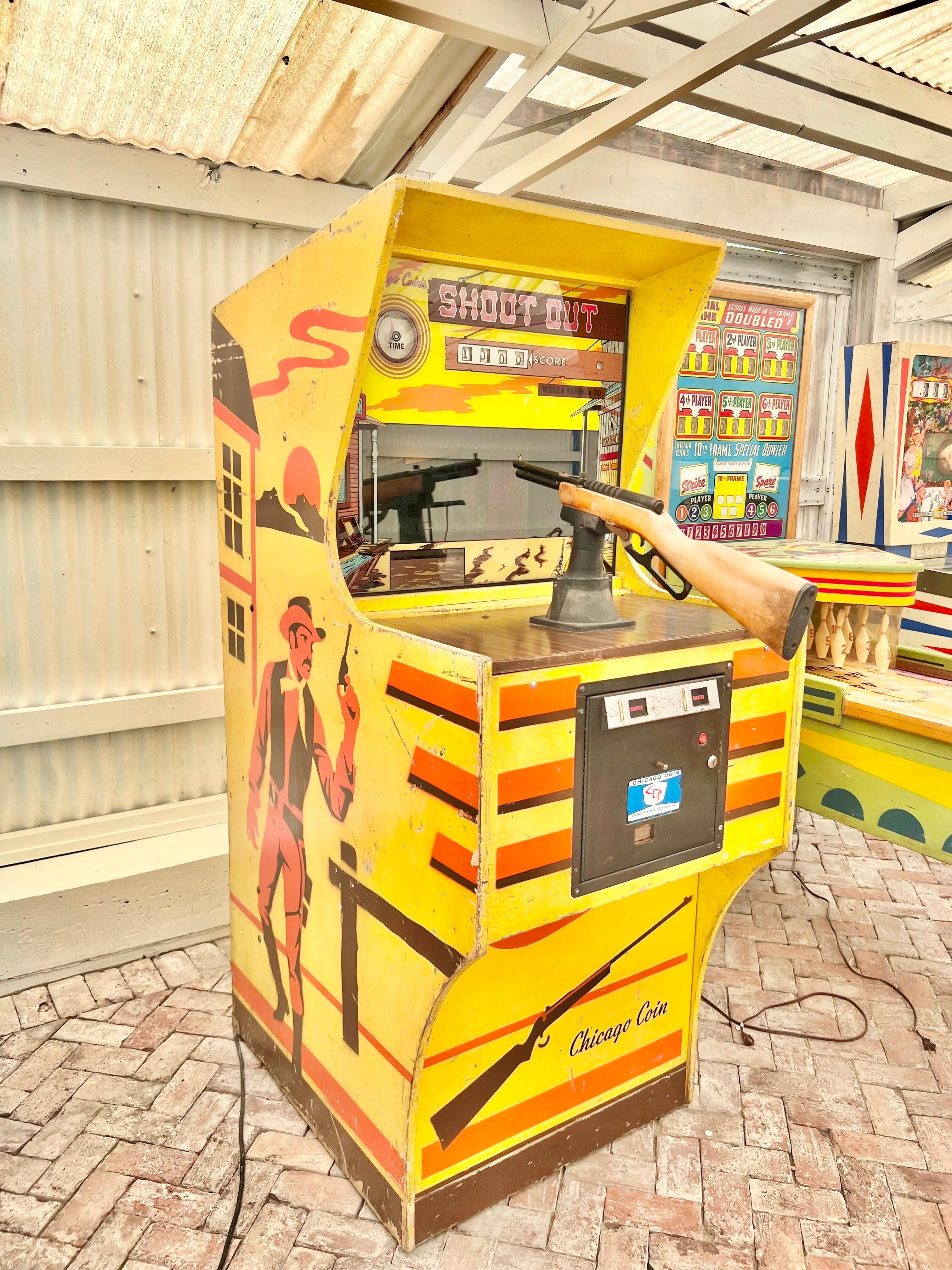 Vintage 1976 ‘Shoot Out’ arcade rifle game manufactured by Chicago Coin Machine Manufacturing Company. Large Dale-style gun game. This machine is housed in wood, painted bright yellow with a western theme stenciled throughout. The game is