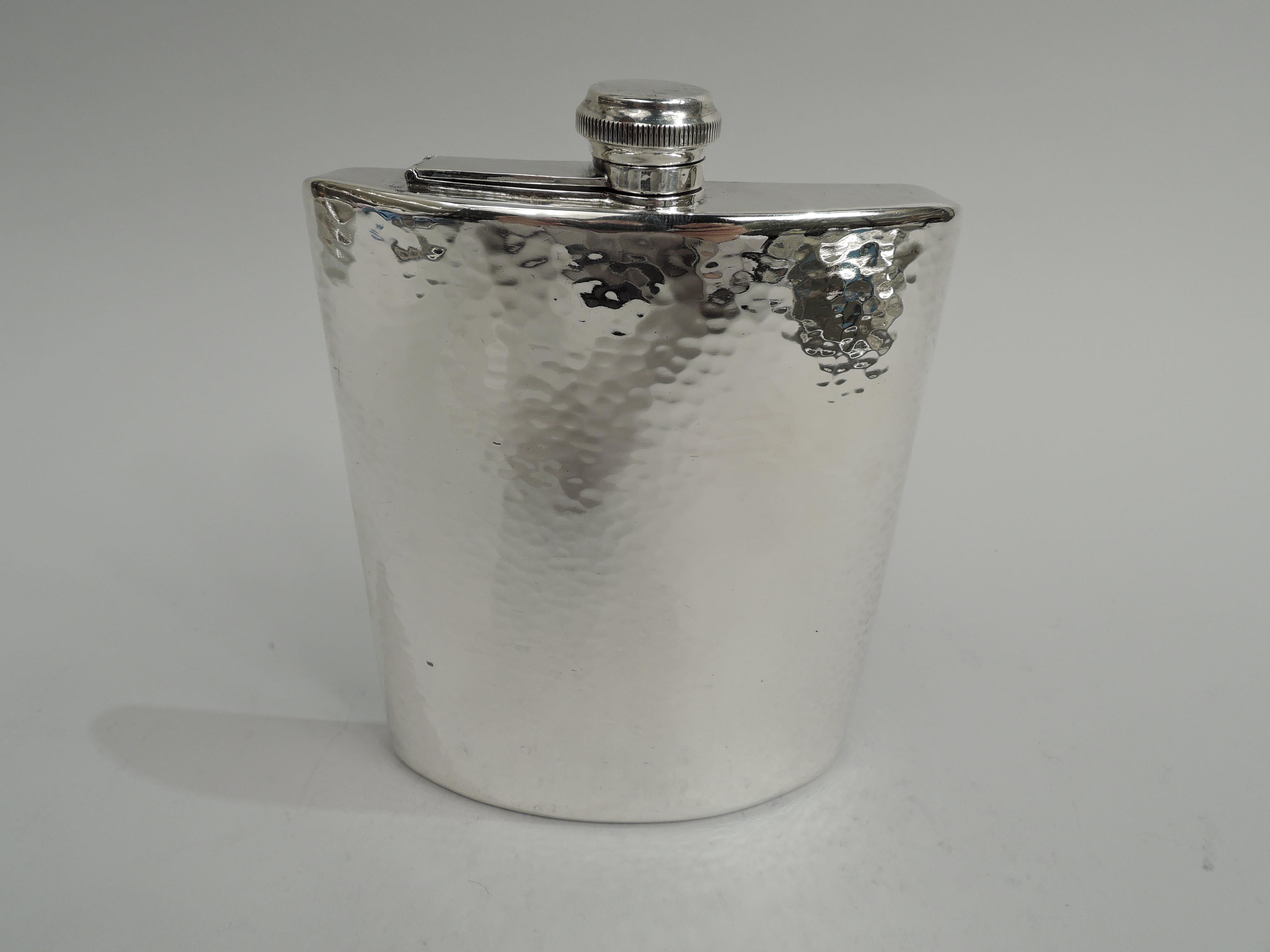 Craftsman sterling silver flask. Made by Lebolt & Co. in Chicago, ca 1920. Curved with flat top and bottom; hinged and cork-lined cover. Allover hand-hammering. Holds 3/4 pint of homemade brew. Wide working-man’s handspan required. Fully marked