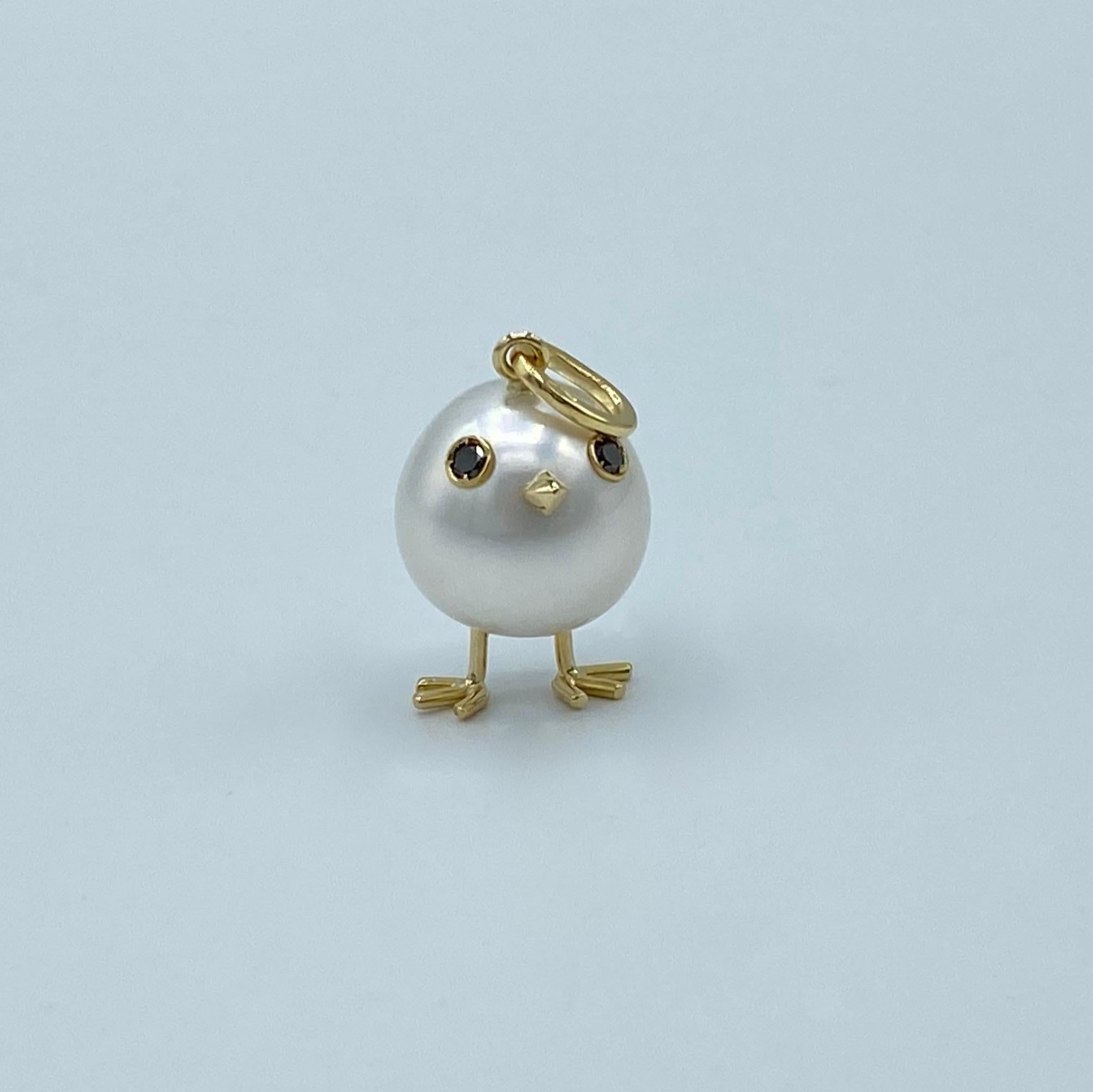 Chick Australian Pearl Black Diamond Yellow  18Kt Gold Pendant or Necklace
A oval shape Australian pearl has been carefully crafted to make a chick. He has his two legs, two eyes encrusted with two white diamonds and his beak. 
The 18KT gold is