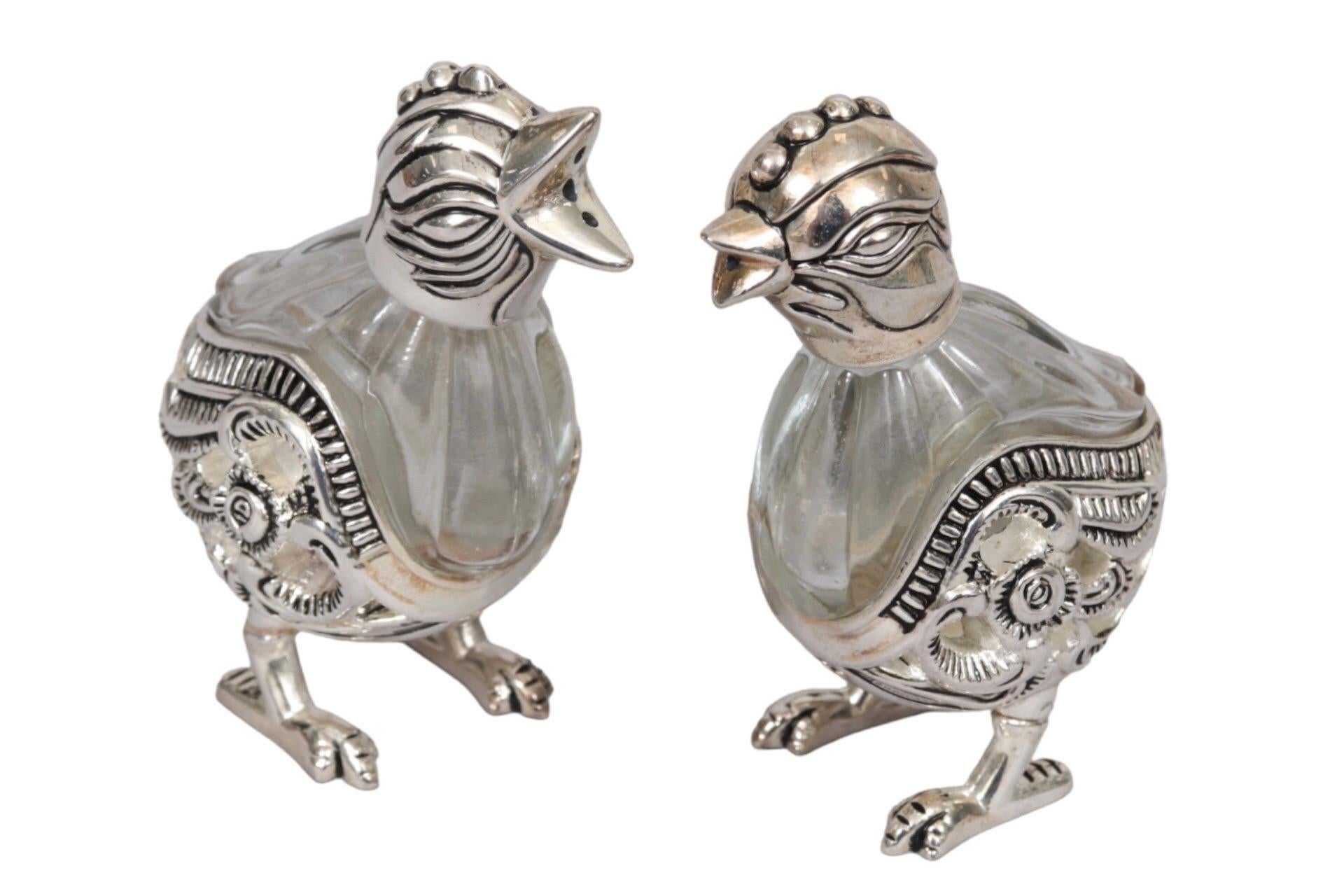 A pair of silver plated and cut glass salt and pepper shakers in the shape of chicks. Made by Godinger Silver Art Company for Neiman Marcus. Ornately cut glass vase bodies are finished with silver plate details including caps shaped like birds'