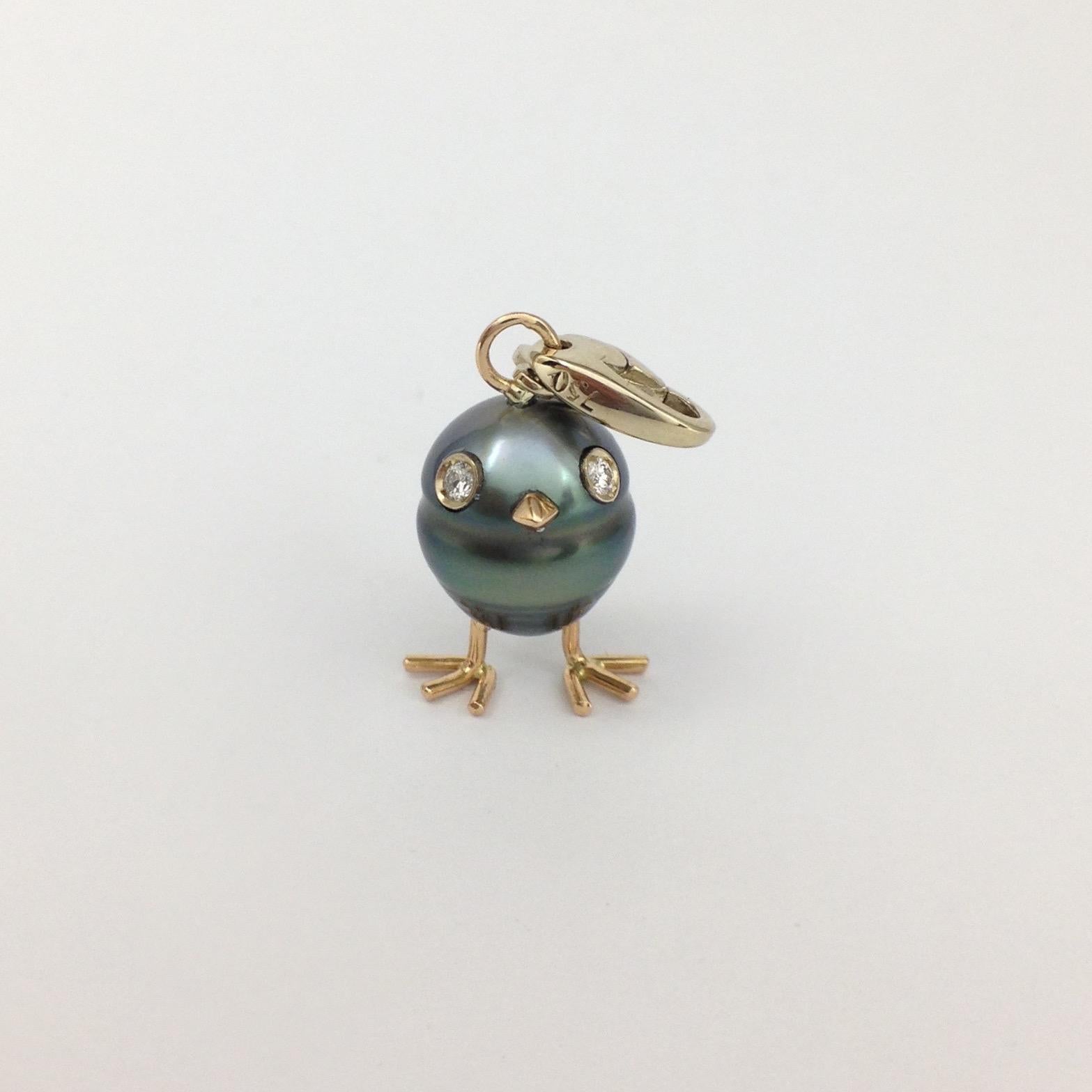 A Tahitian pearl has been carefully crafted to make a chick. He has his two legs, two eyes encrusted with two white diamonds and his beak. 
The gold is white for the eyes and the carabiner, for the other particulars it's red.
The caliber is ct