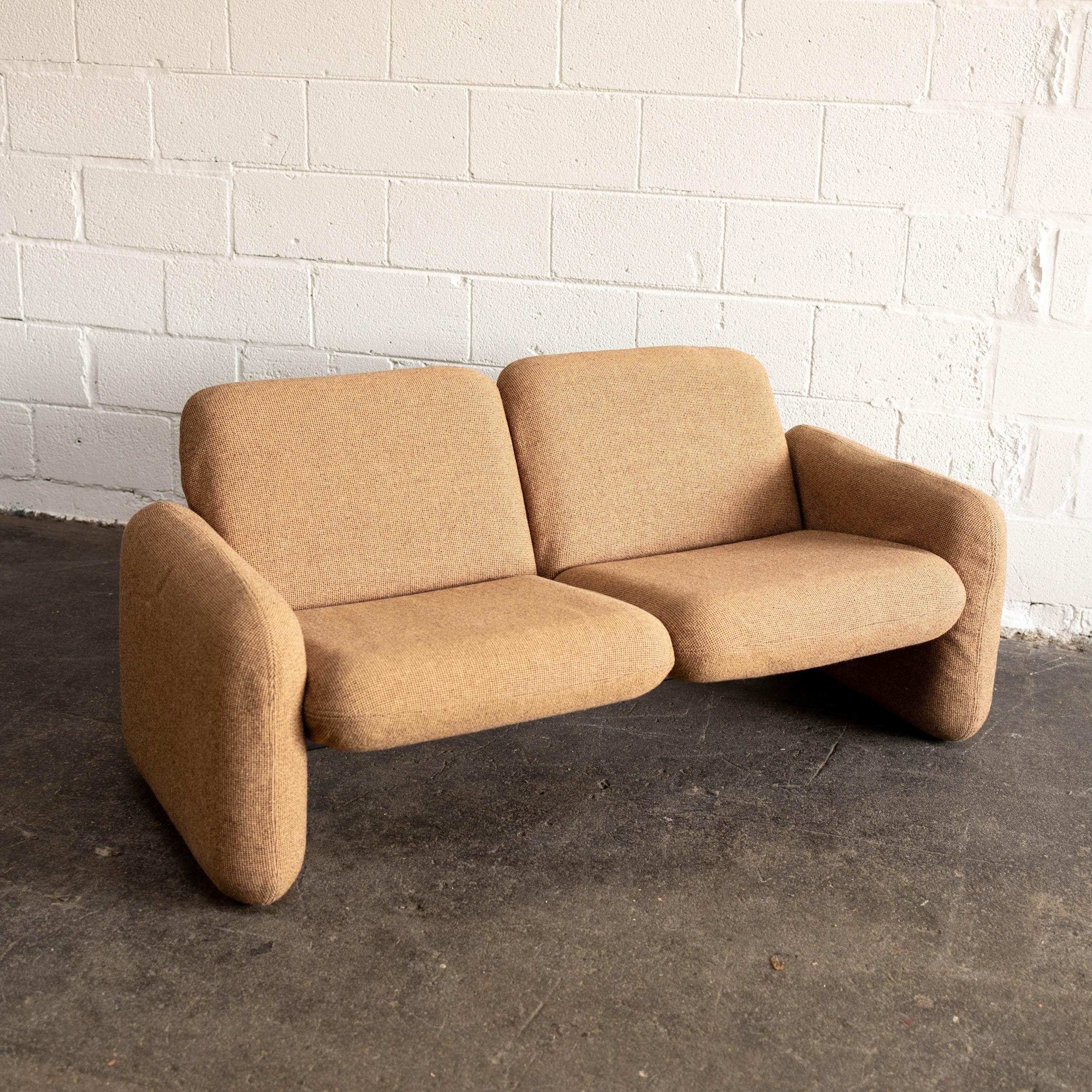 This piece features its' original brown tweed upholstery. When the design was first created, it was revolutionary in the way that it used injection-molded foam to create modular designs.