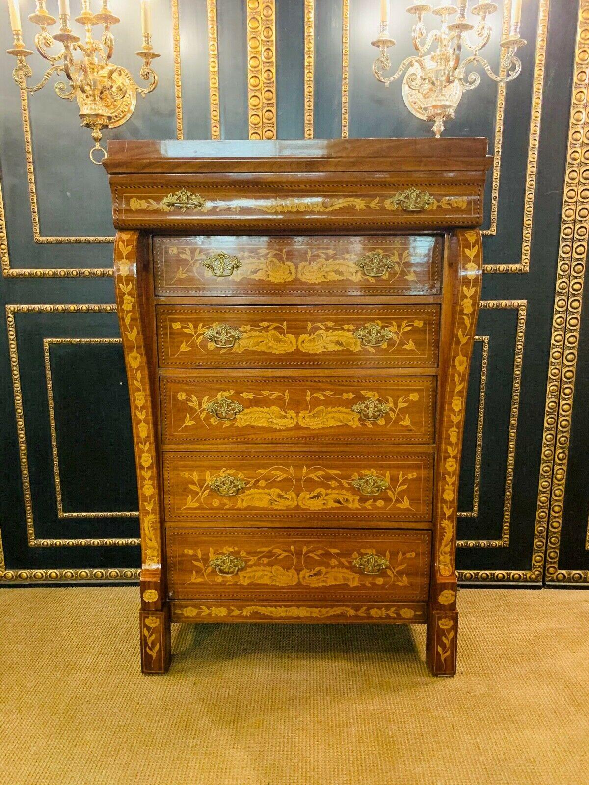 Chiffionere / men's chest of drawers with 6 drawers in Dutch baroque style inlaid with floral inlays.
Right and left with beautiful volute-like flat columns.
Solid wood with exotic veneer.