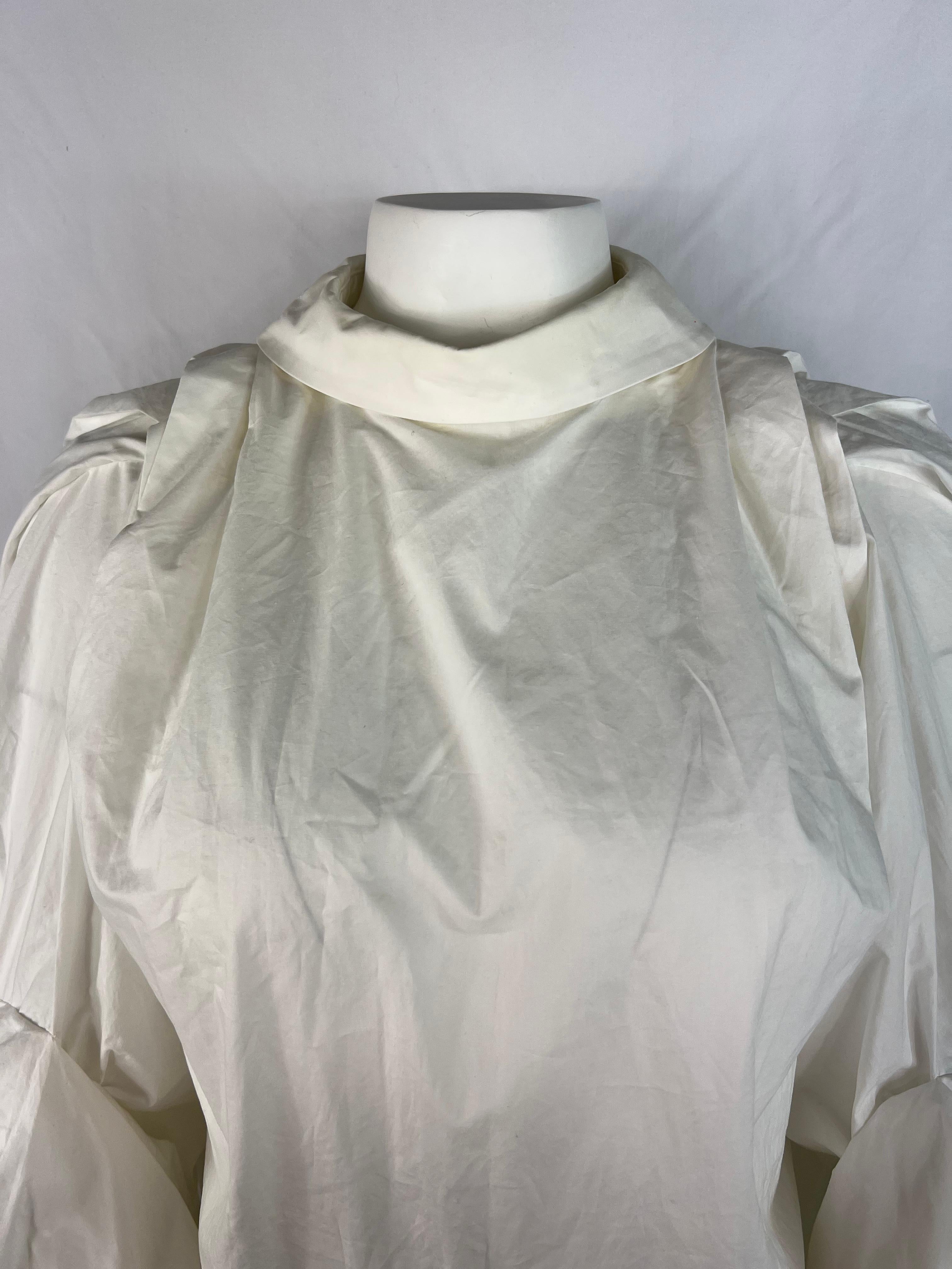 Product details:

The bourse is made out of 100% white cotton. It features collar, loose fit with rear zip and button closure, and 3/4 sleeves length.