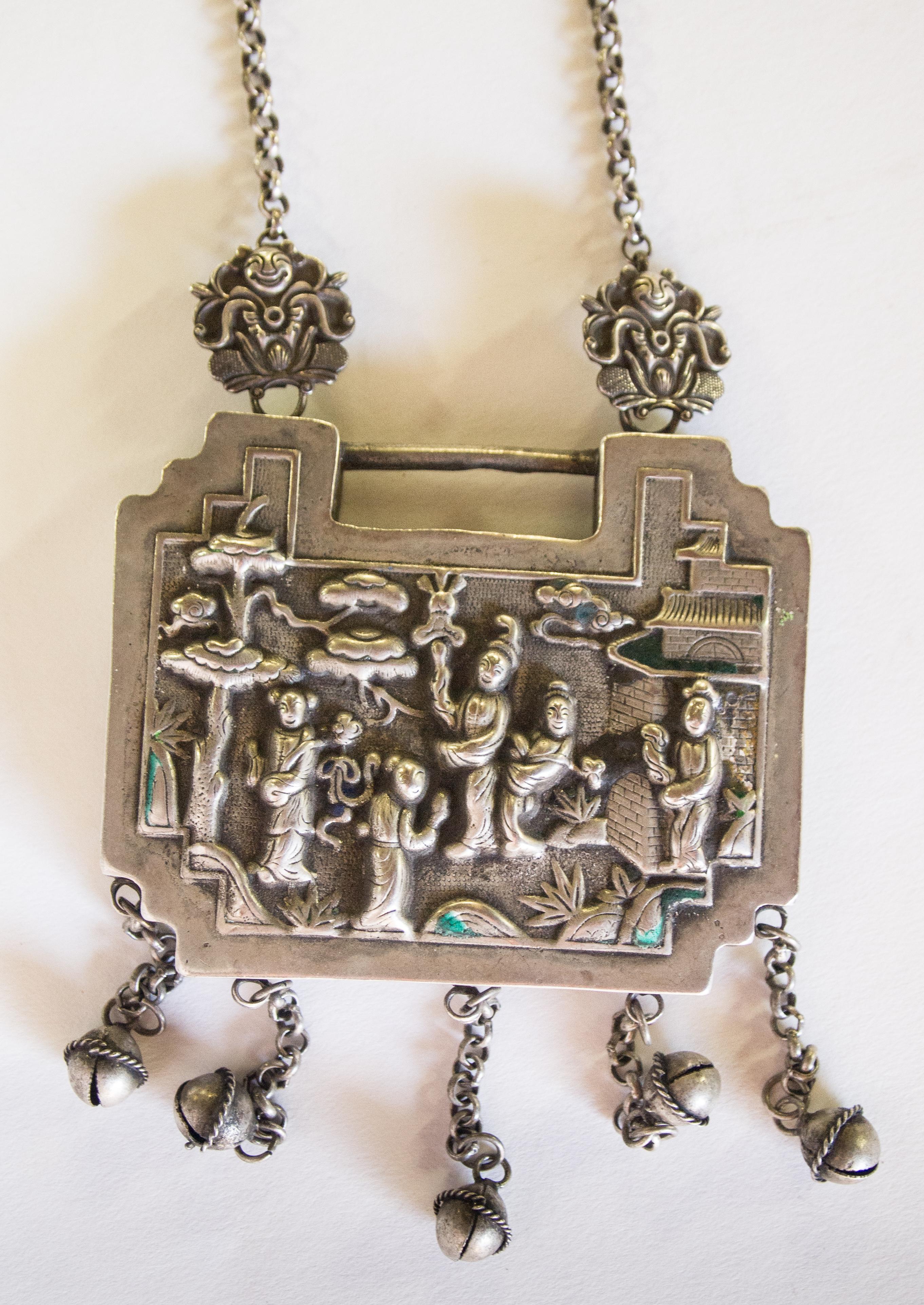Child amulet lock necklace silver alloy with repousse work and hanging bells. Yao or Hmong of SW China, early 20th century. Fastened on a chain necklace.
This charming amulet necklace comes from the Yao or Hmong of Southwest China and features on