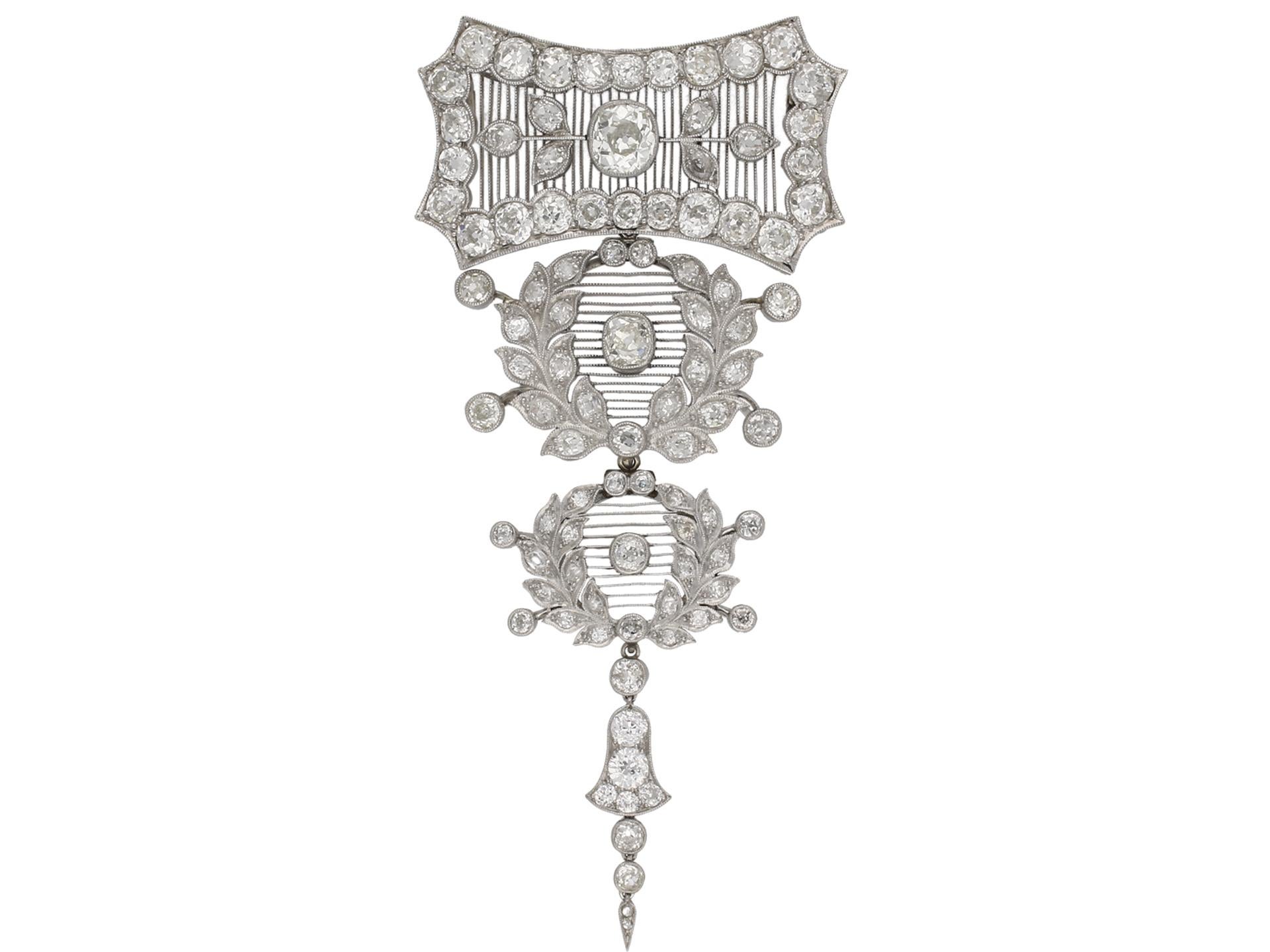 Pendant brooch by Child & Child. A pendant/brooch in three detachable sections, the uppermost composed of an elongated octagon with inward bowed sides set with one central diamond in a collet setting with a weight of 2.50 carats, flanked by trefoil