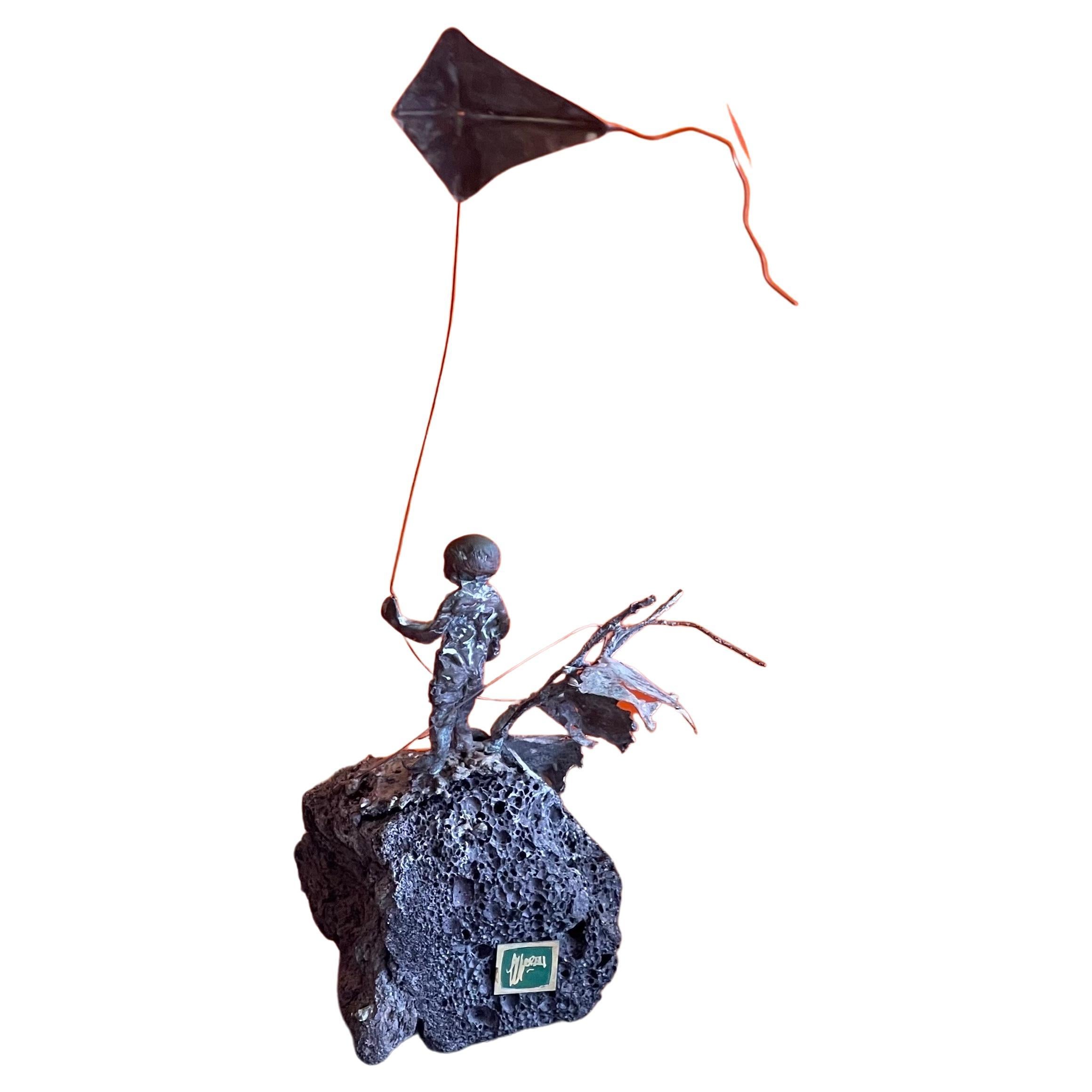 A really cool child flying kite bronze on volcanic rock sculpture by Malcolm Moran, circa 1970s. The piece is in very good vintage condition and measures 10