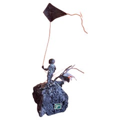Enfant volant en forme de cerf-volant en bronze sur sculpture de roche volcanique de Malcolm Moran