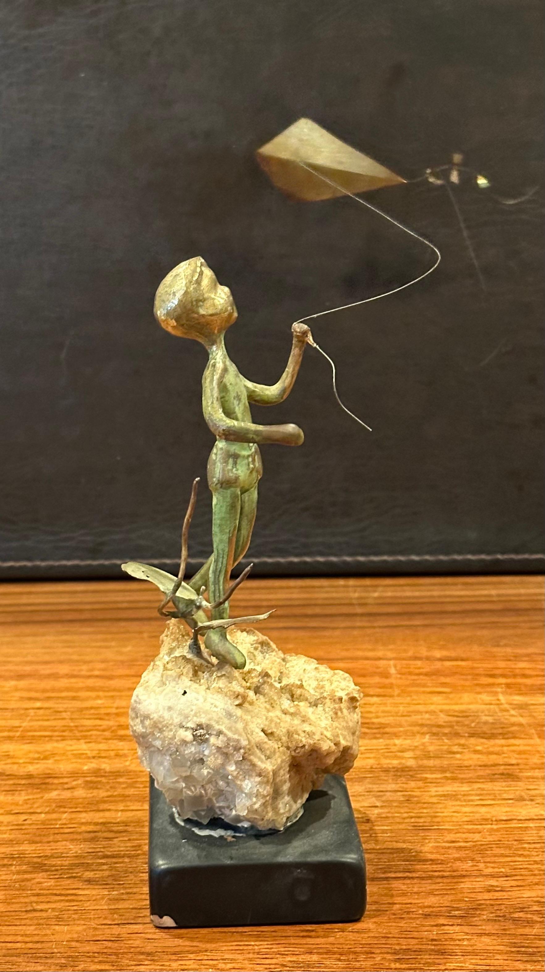 Niño volando una cometa Escultura de bronce sobre roca volcánica de Malcolm Moran siglo XX en venta