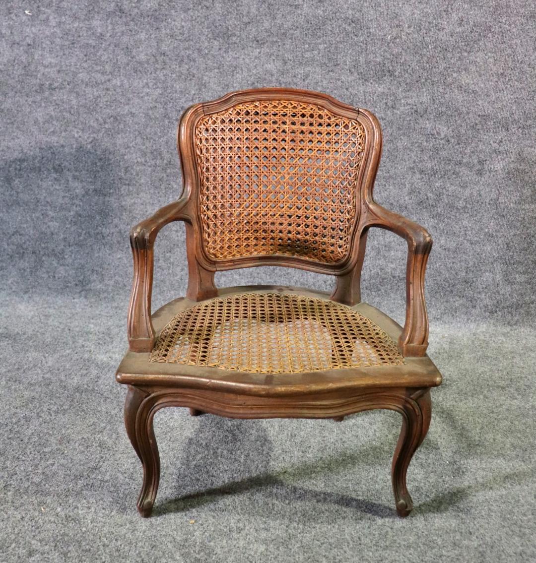 Louis XV style cane arm chair, pettie, childs size. Solid wood frame and arms. Cane back and seat. Does show scratches and finish loss. Minor break in cane.


Dimensions: 23 1/4