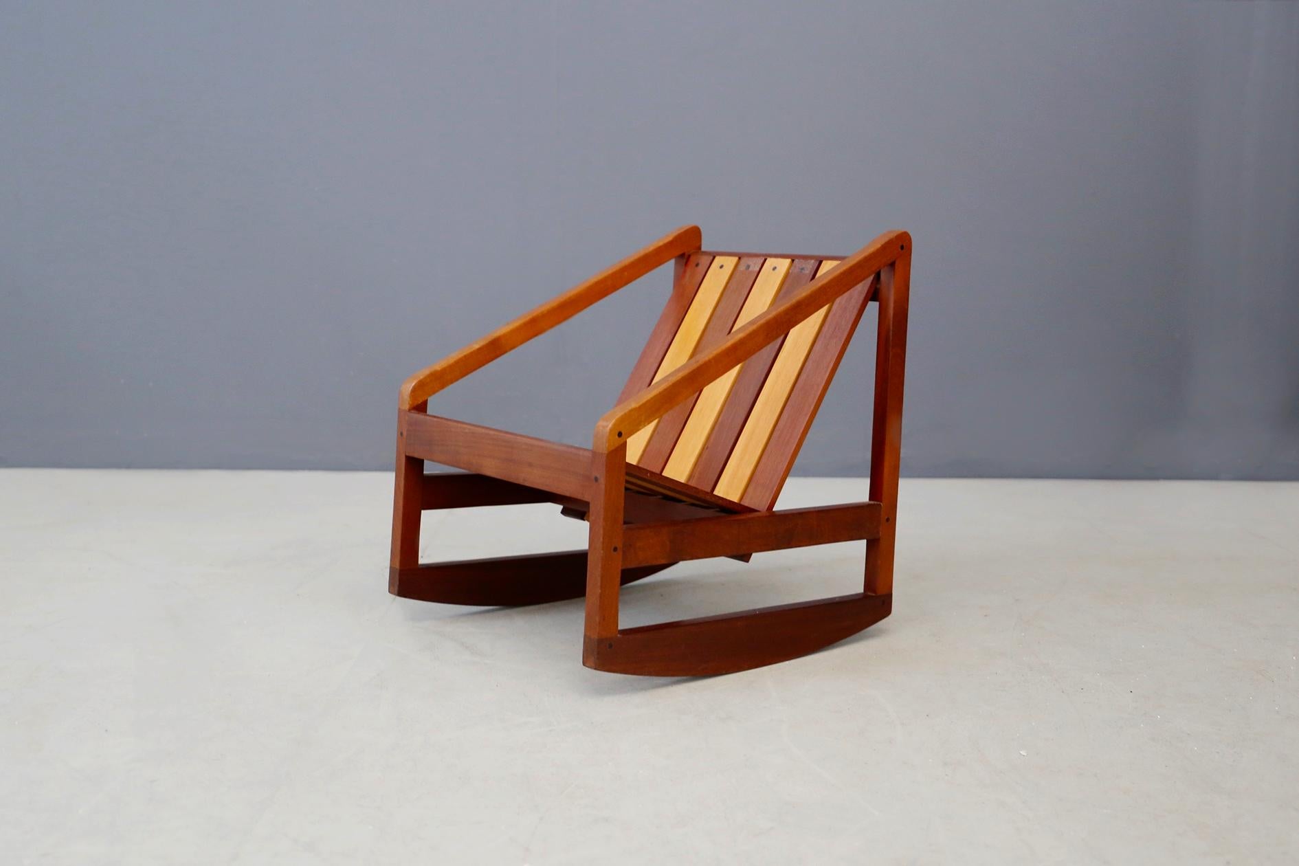 Rocking chair for children made and designed by the great Italian cabinetmaker Pierluigi Ghianda, 1960/70s. The rocking chair is made of various essences of fine wood. Its seat and backrest are made of wooden slats. The small rocking chair was taken