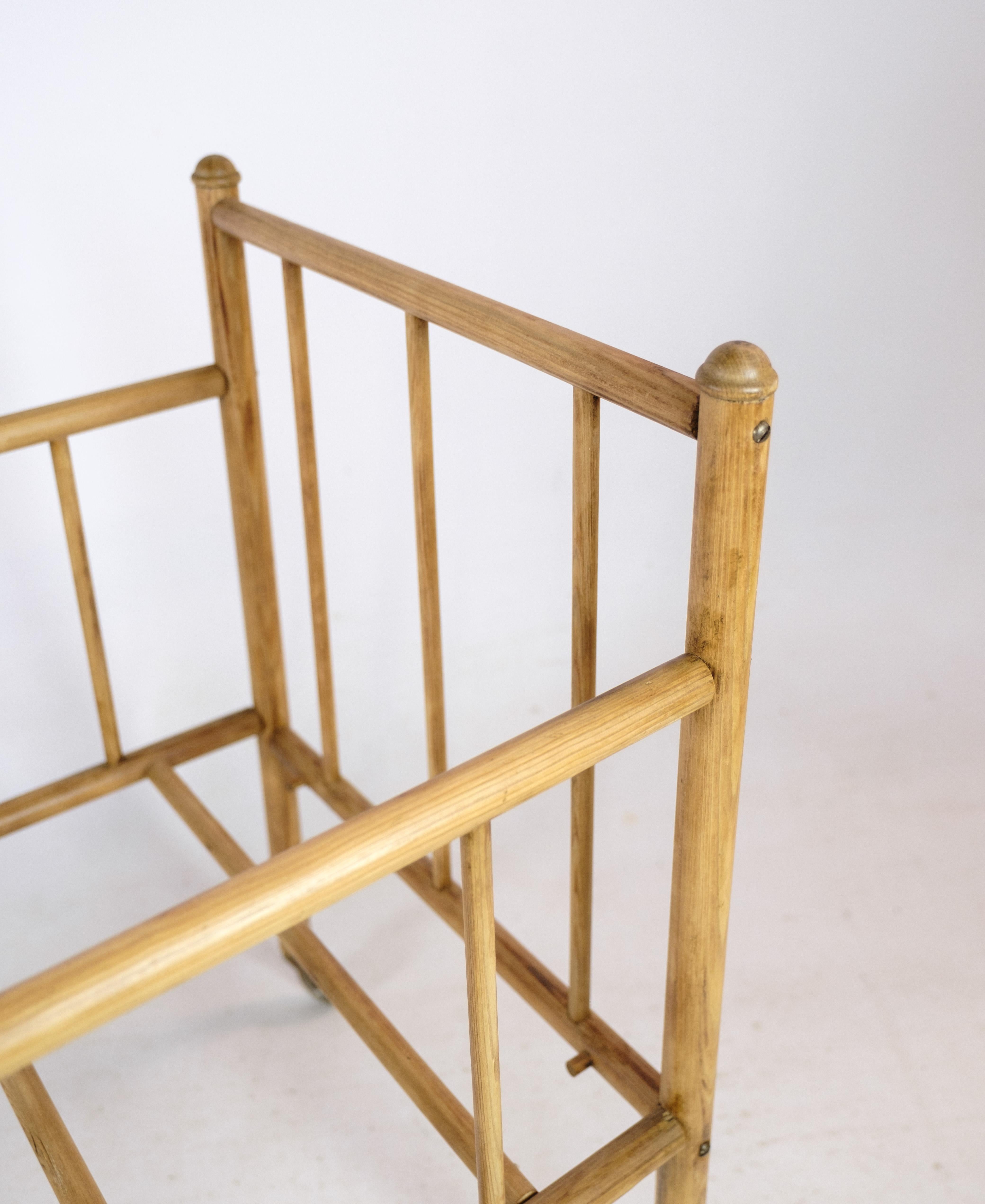 This antique crib, made from light pine wood and equipped with wheels for easy movement, offers a charming glimpse into the nursery furniture of the 1920s. While details about the designer and manufacturer are unavailable, the crib's timeless design