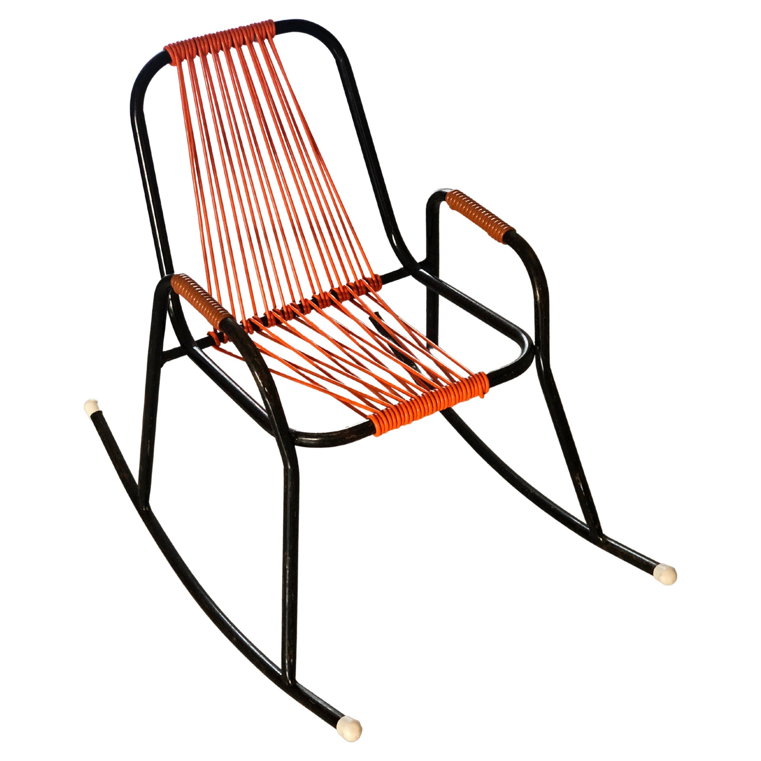 Children's Rocking Armchair scoubidou Torck - 1950's
Cute little Vintage Rocking Armchair for children from the fifties. Black tubaler metal frame, and seat, backrest and armrests in scoubidou orange plastic wire. Special model. 

Torck was founded