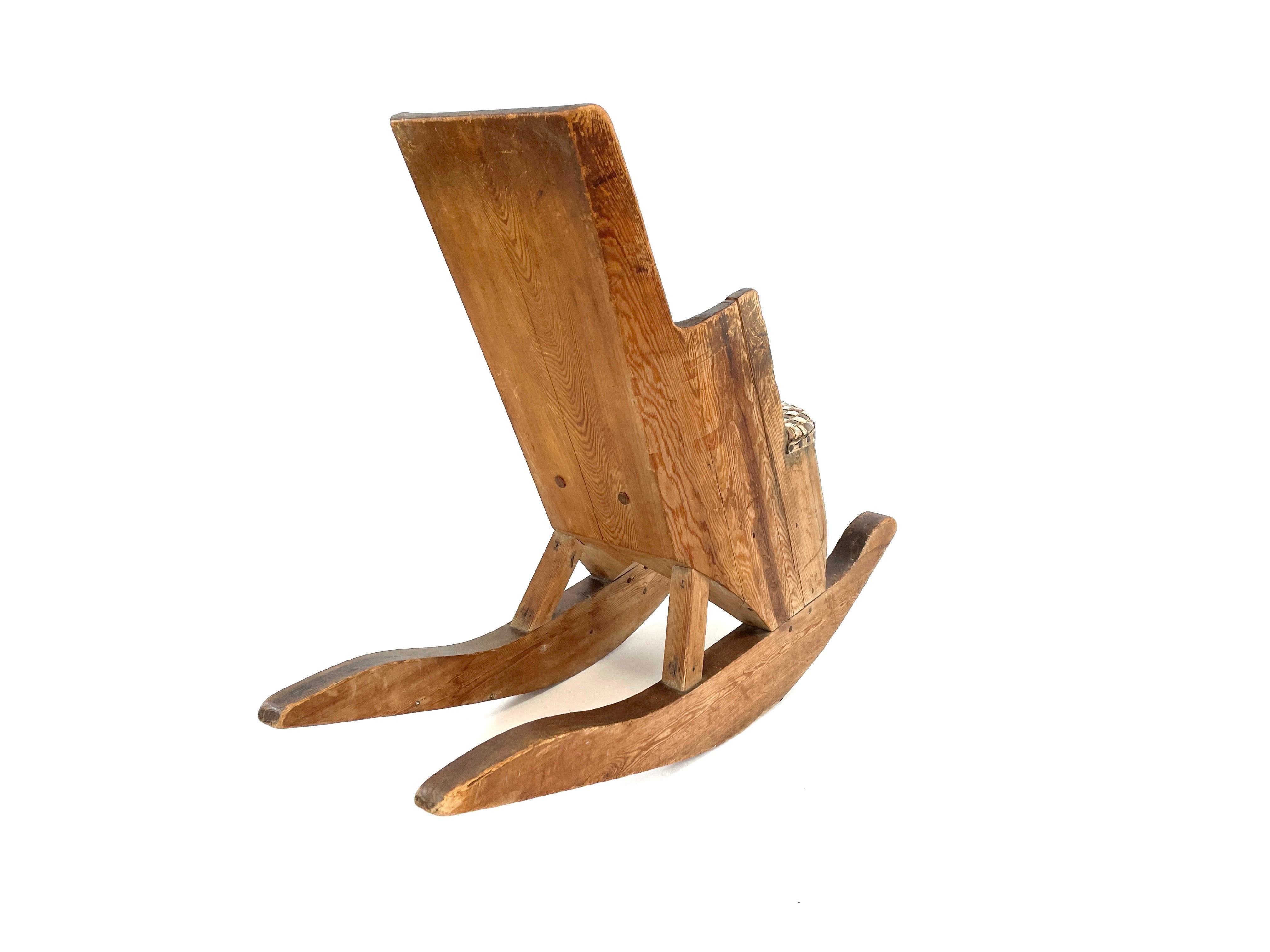 Remontez le temps avec notre charmante chaise à bascule pour enfants, fabriquée à la main au début des années 1900 par un artisan finlandais au talent méconnu. Cette pièce unique présente un design Arts & Crafts, avec un siège en écorce de bouleau.