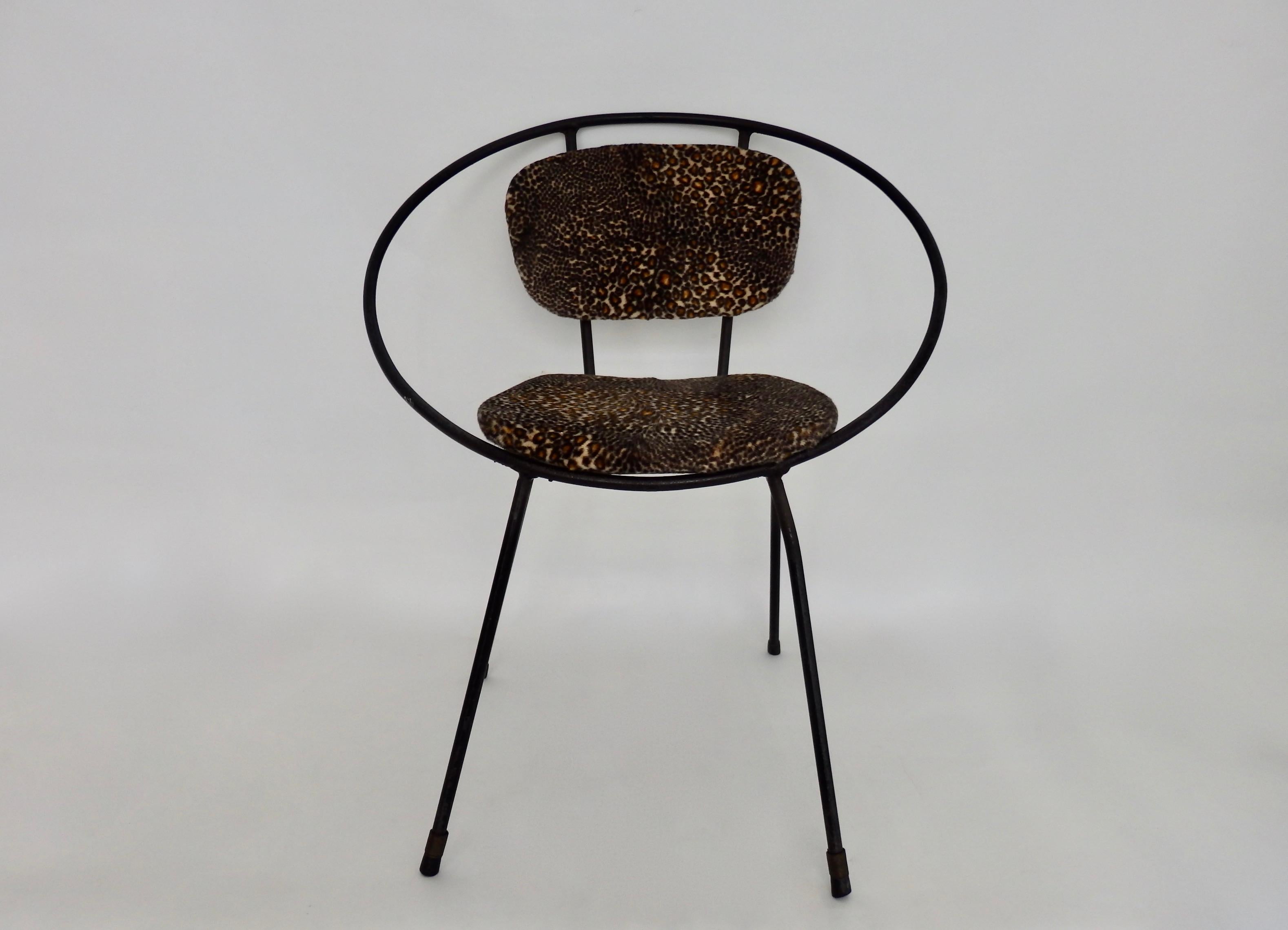 In the style of Tony Paul, a stylish children's hoop chair or salesman sample made of wrought iron and leopard print fabric.