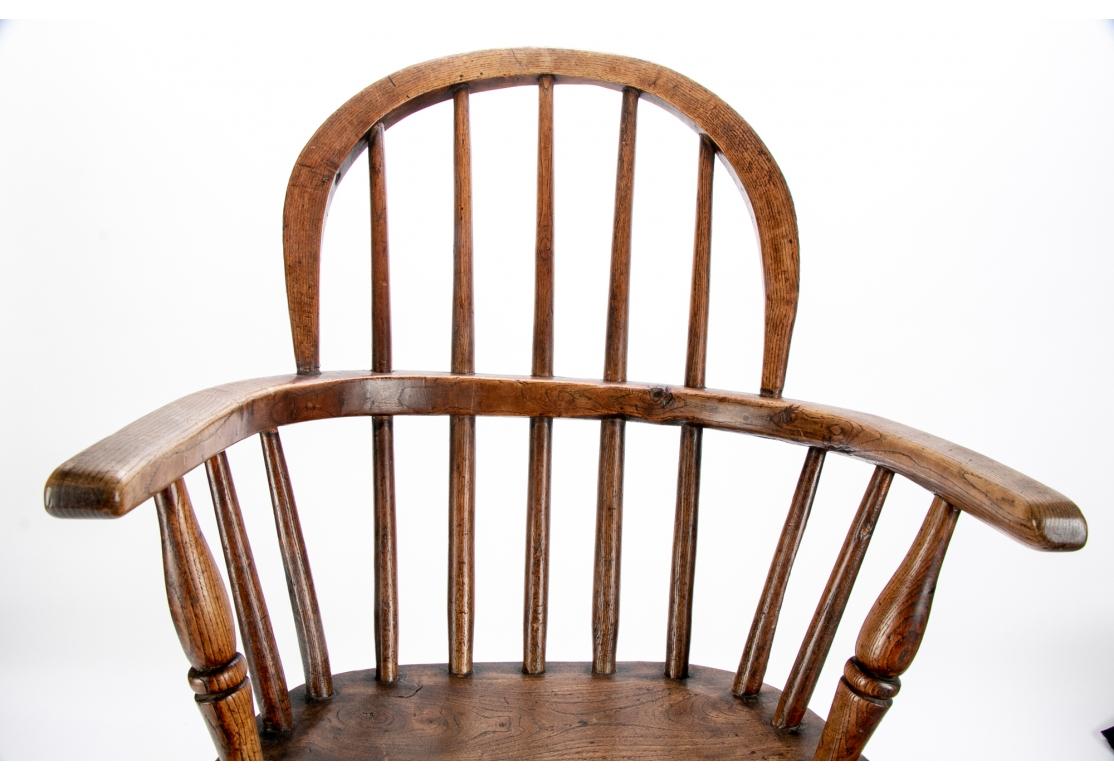 Ein antiker Hartholz-Windsor-Sessel für Kinder mit klassischer Reifrückenlehne mit Spindeln und geformtem Sitz. Auf gespreizten, gedrechselten Beinen mit gedrechselter H-Lehre aufgerichtet. 
Maße: H. 25 1/2