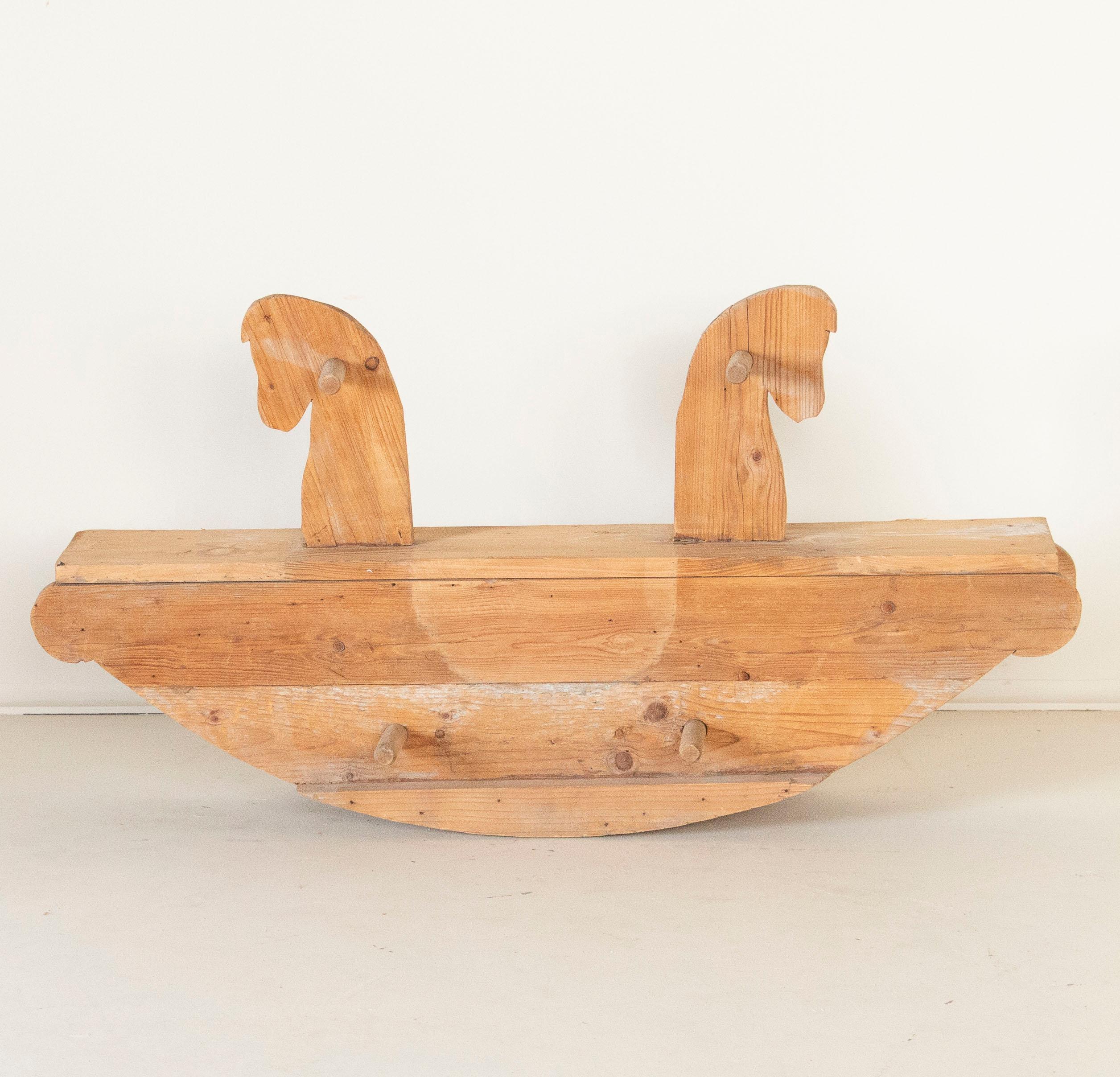 This antique child's seesaw in the form of a rocking horse was made for two to play and constructed out of pine. Also referred to as a teetertotter, this working toy has an almost folk art quality with it's simple construction and style. Nothing has