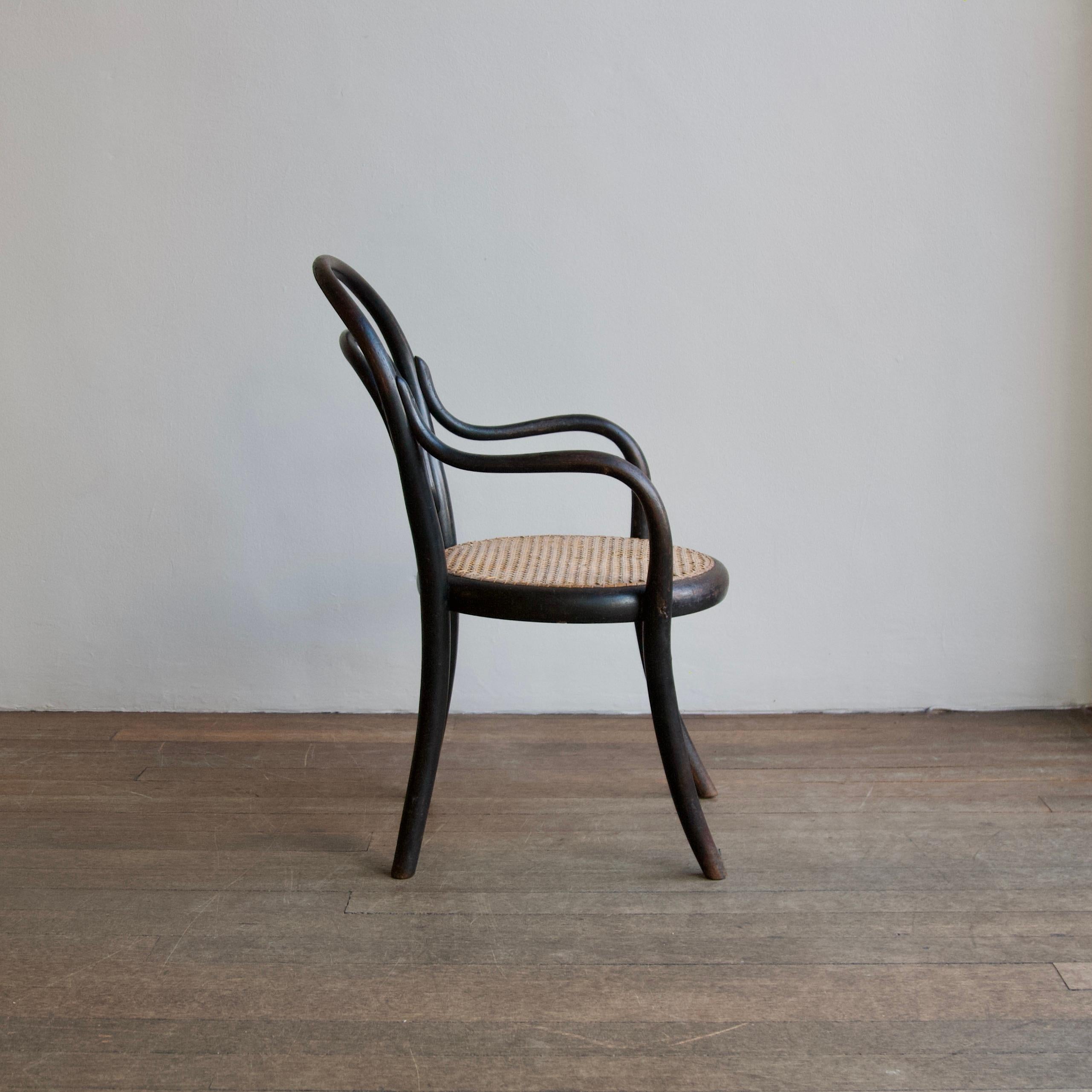 A bentwood and cane child’s armchair in black lacquer by Thonet, Austria.

The chair features all of the attributes associated with the iconic Thonet design vernacular. All of the structural elements from the legs to the backrest have been expertly