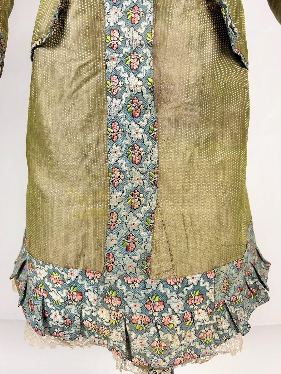 Circa 1870
France
A child's dress, for a boy (?) around 10 years old (?), reused from older silks dating from the 19th century. The base is a yellow-green edged taffeta with a small sowing, as was the case with many Directoire and First Empire