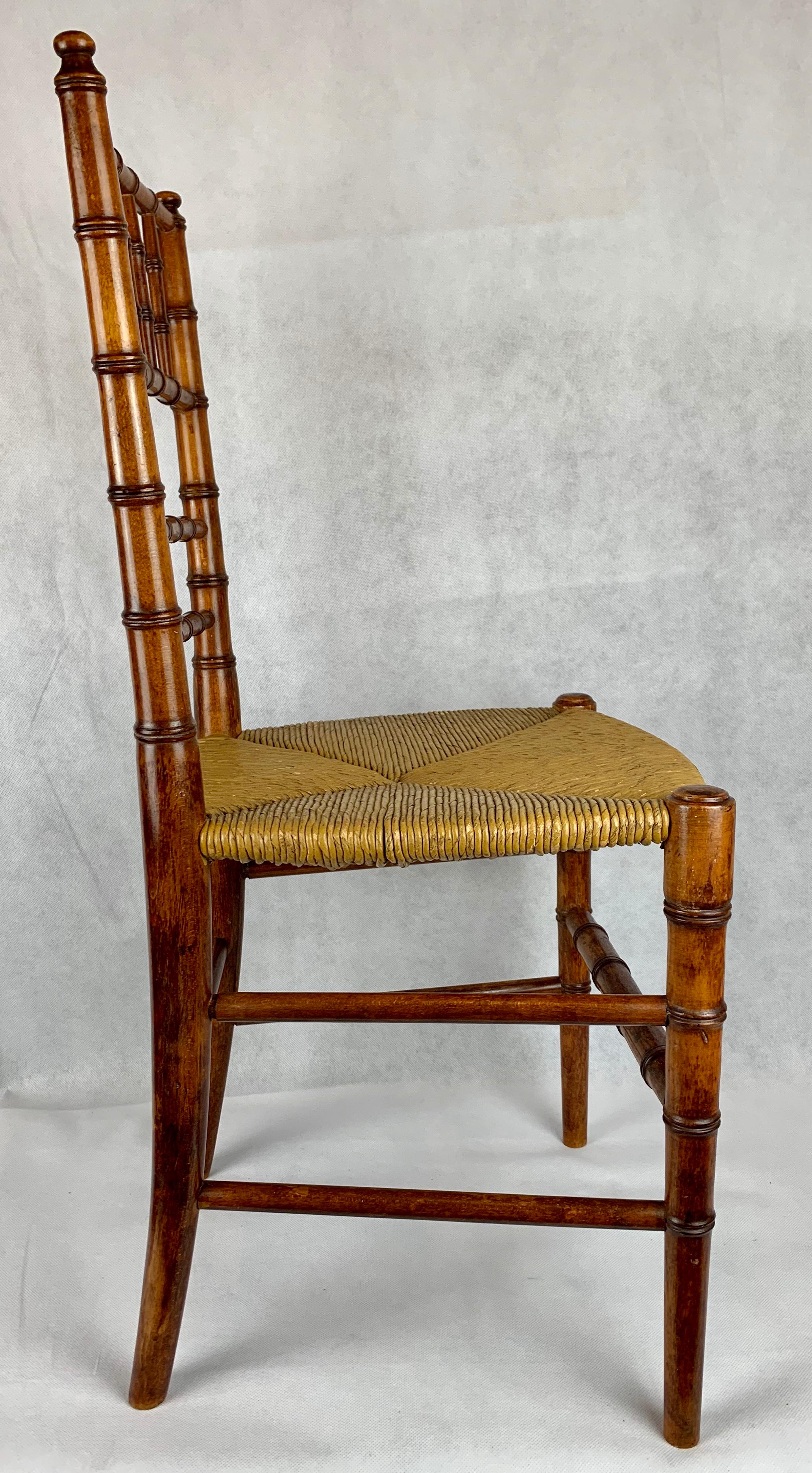 French child's hand turned faux bamboo side chair with rush seat and six stretchers.  (Adorable)
. Also useful in a powder room to hold towels, magazines, etc.
Structurally very strong even for an adult.
Hand polished in our workshop.
 The seat