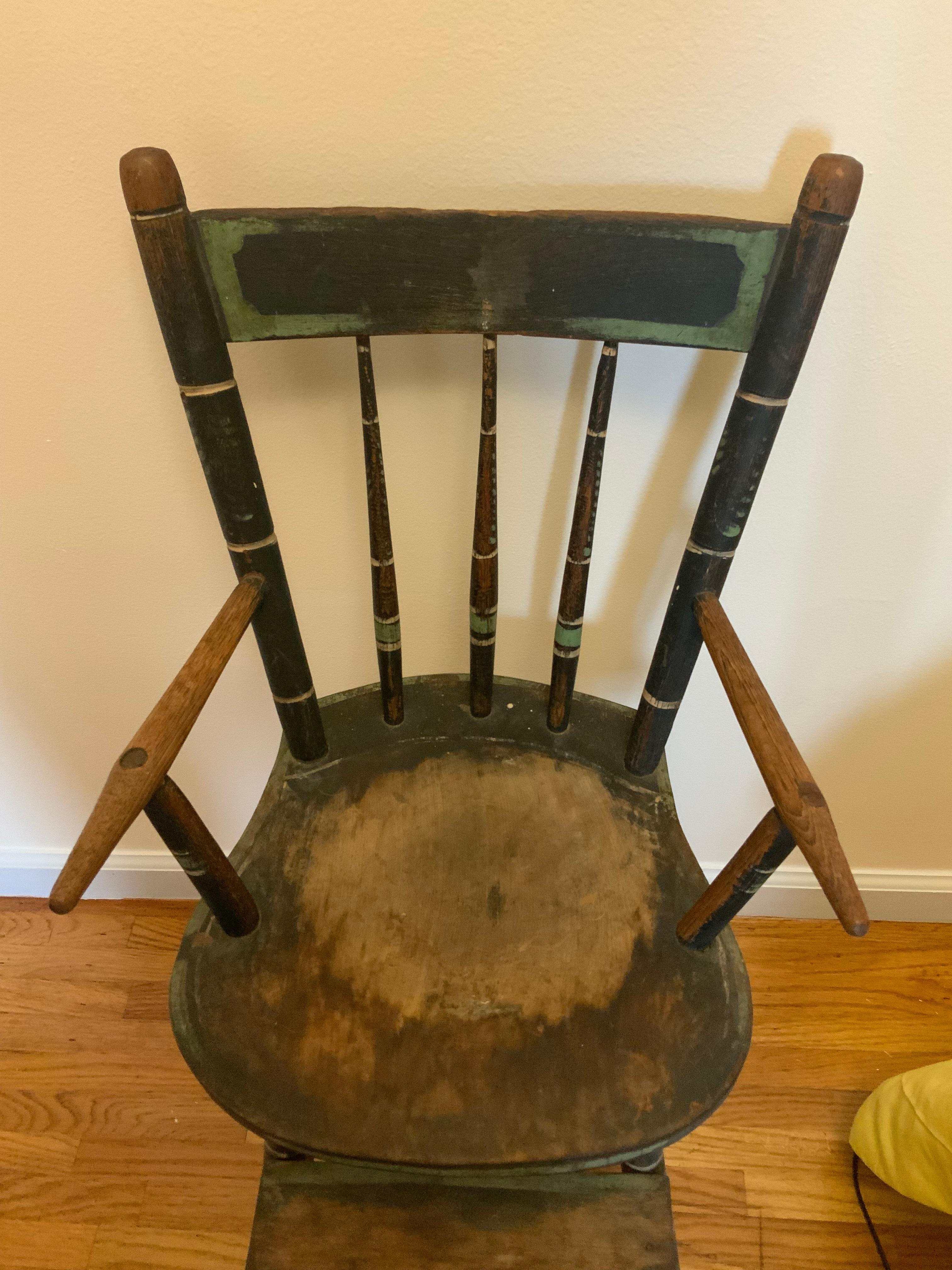 Très belle chaise haute pour enfant de style Windsor, décorée au pochoir et à la peinture, dans son état de surface usé et sec d'origine. Le siège est une planche de pin et le bois secondaire ressemble à de l'orme ou du caryer. Un très bel exemple