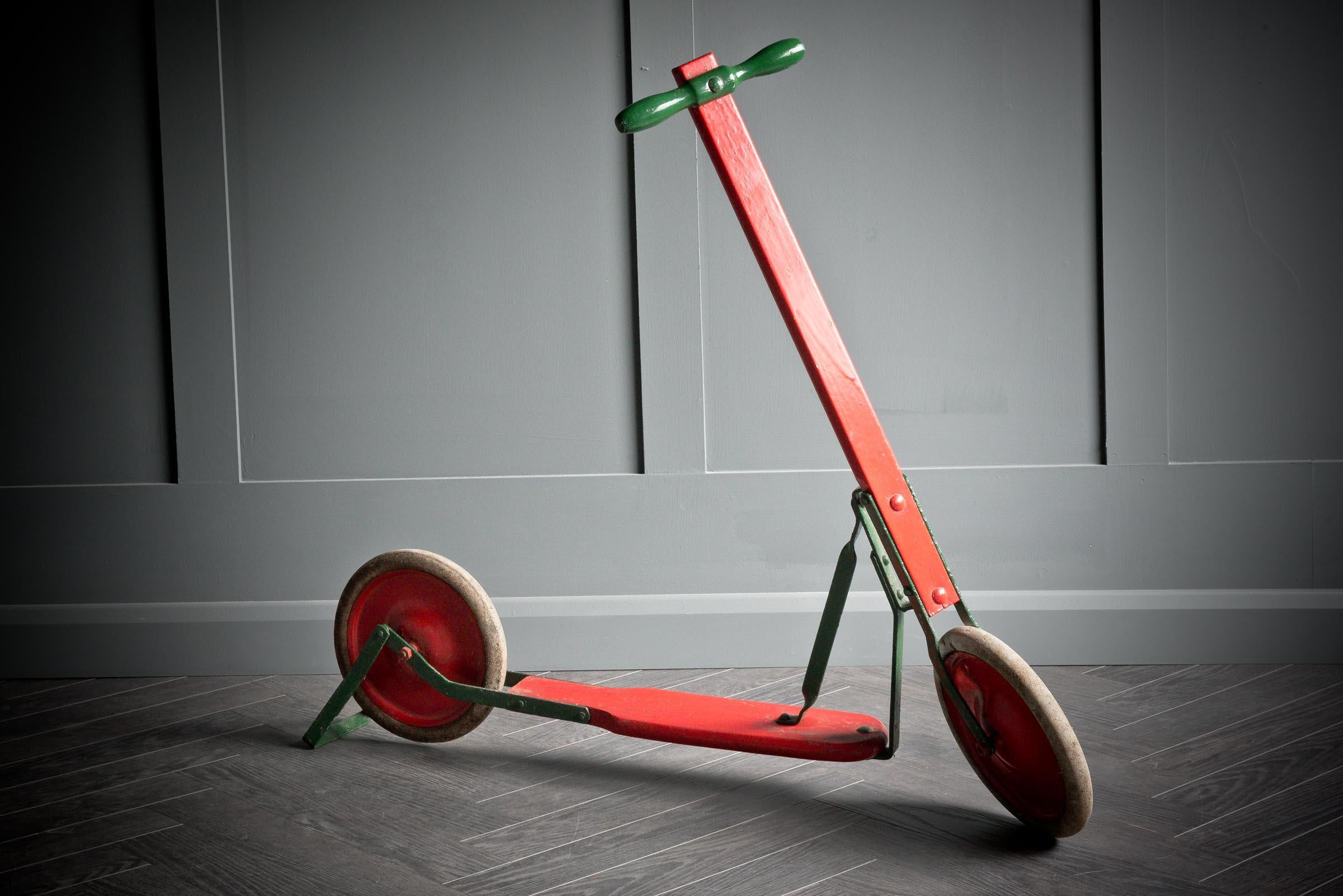 1950's Wooden scooter painted in red with green metal components and brake. 