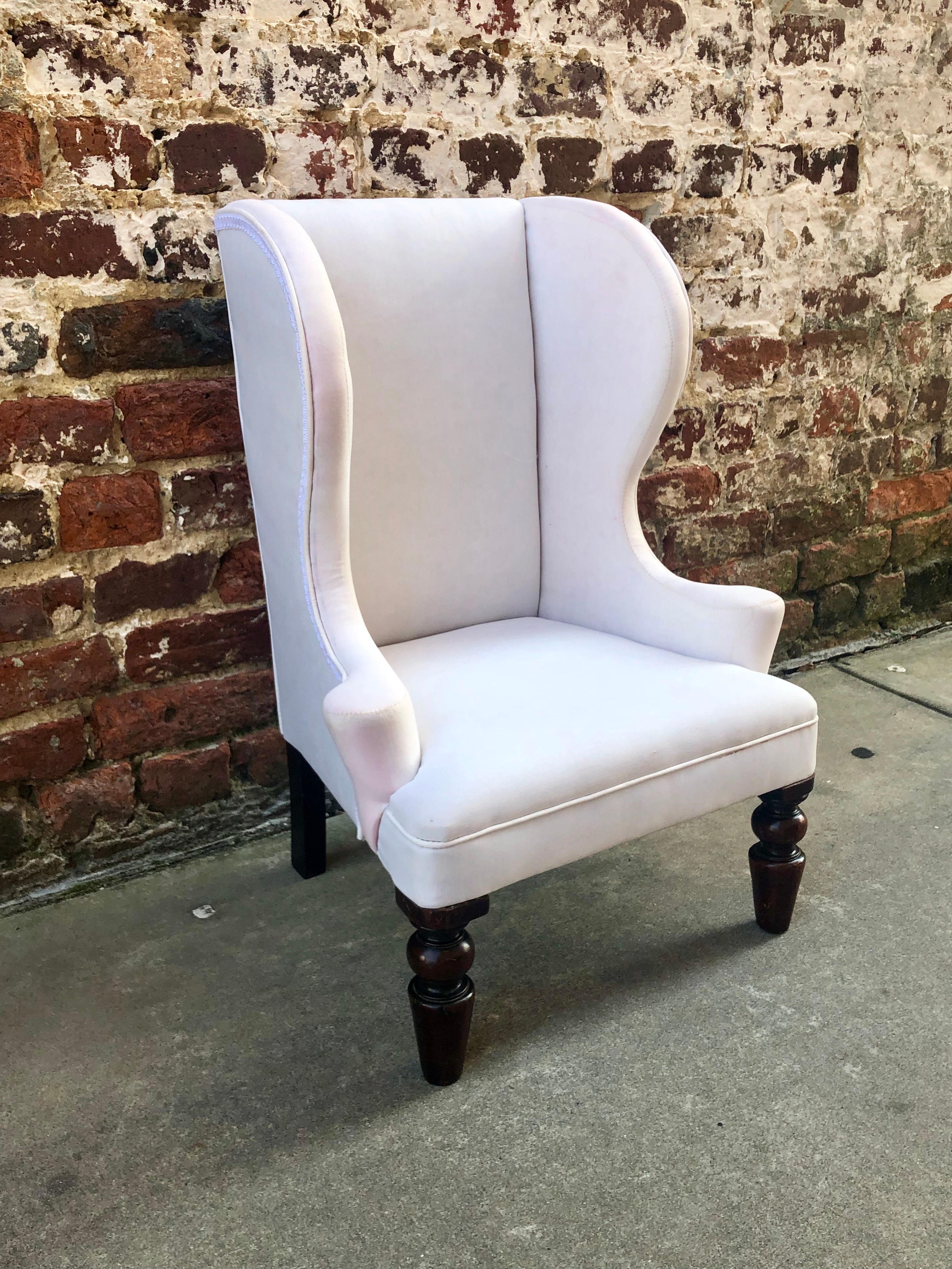 Child’s wingback chair with nicely done outward curved arms. Mahogany turned front legs with splayed simple back legs.