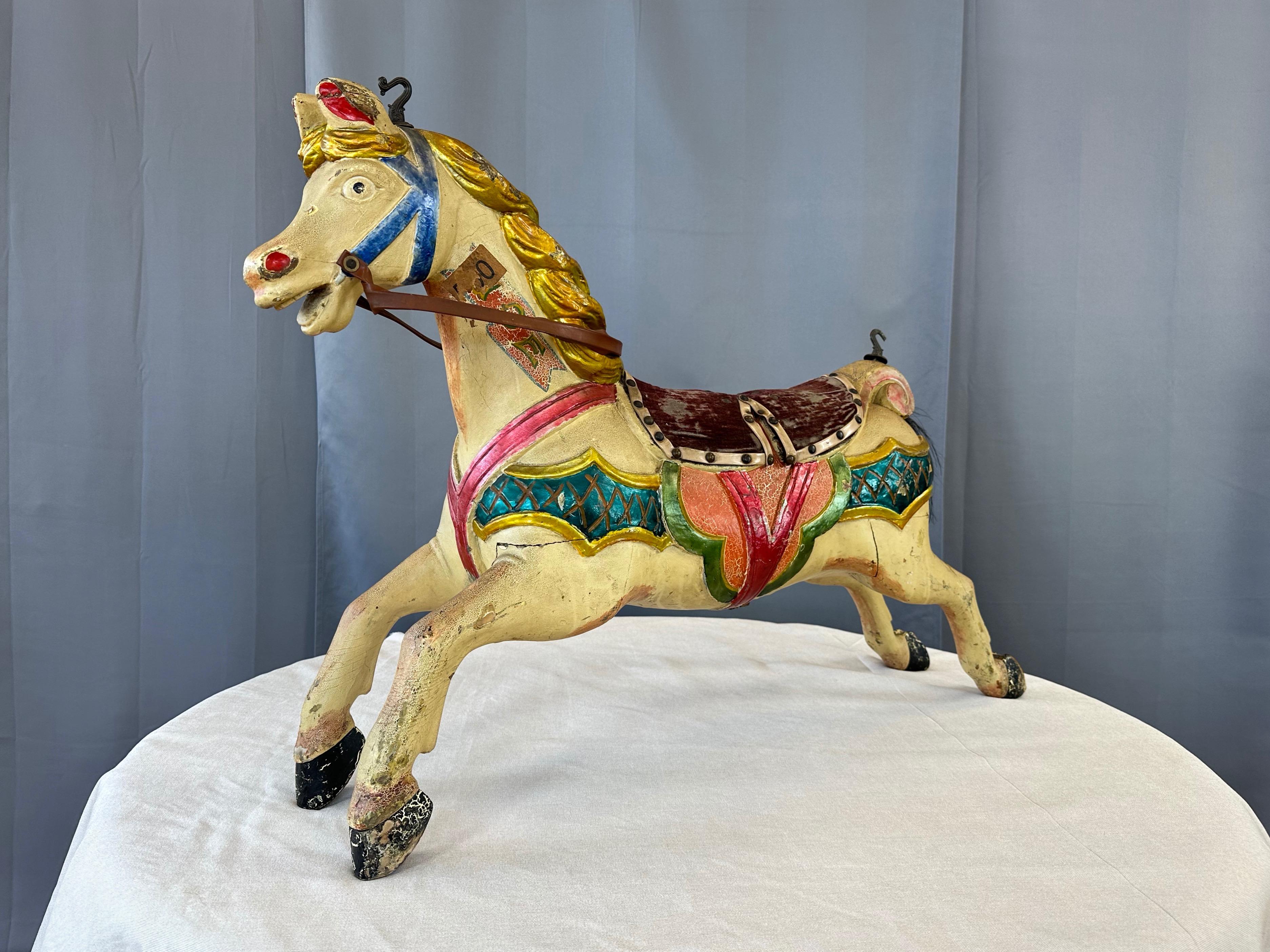Ein sehr charmantes und farbenfrohes CIRCA 1920 antikes Kinderkarussellpferd aus Holz mit polychromer Oberfläche, Mohair-Sattel und Pferdeschwanz.

Dieses handgeschnitzte Holzkarussellpferd in Kindergröße hat einen aufgeregten Gesichtsausdruck und