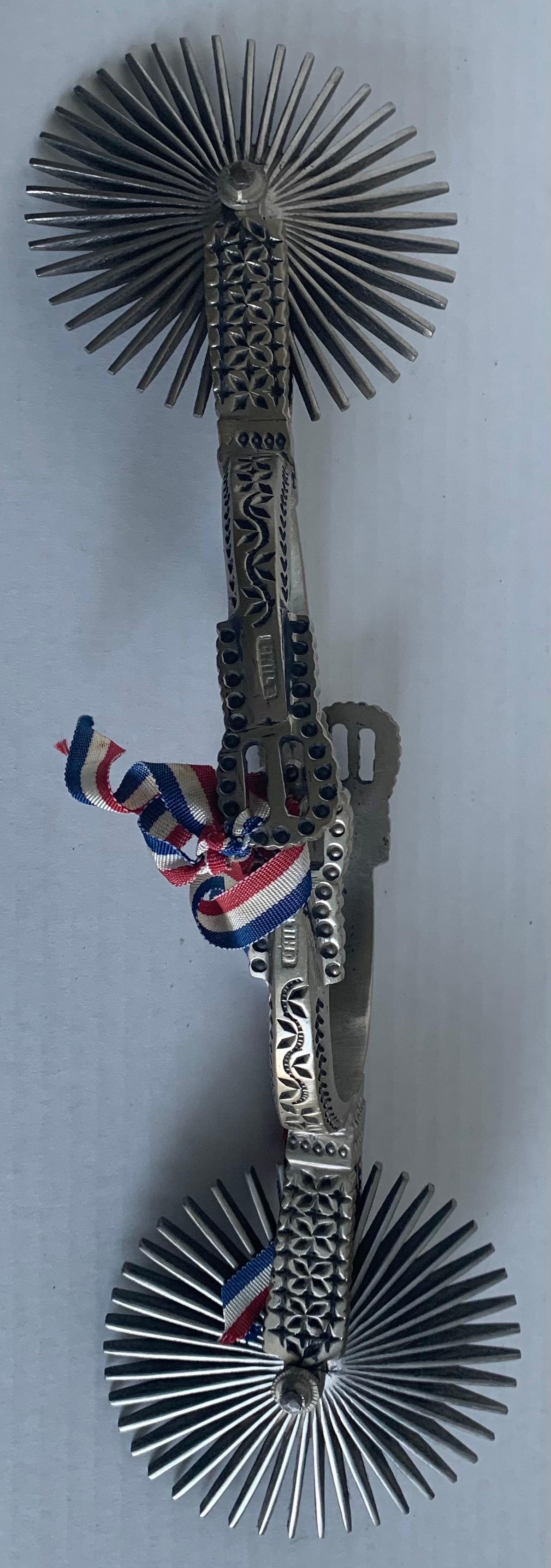 Early 20th century Chilean huasos metal spurs. Heavy silvered metal stamped Chile on the side. As found with grosgrain ribbon attached.