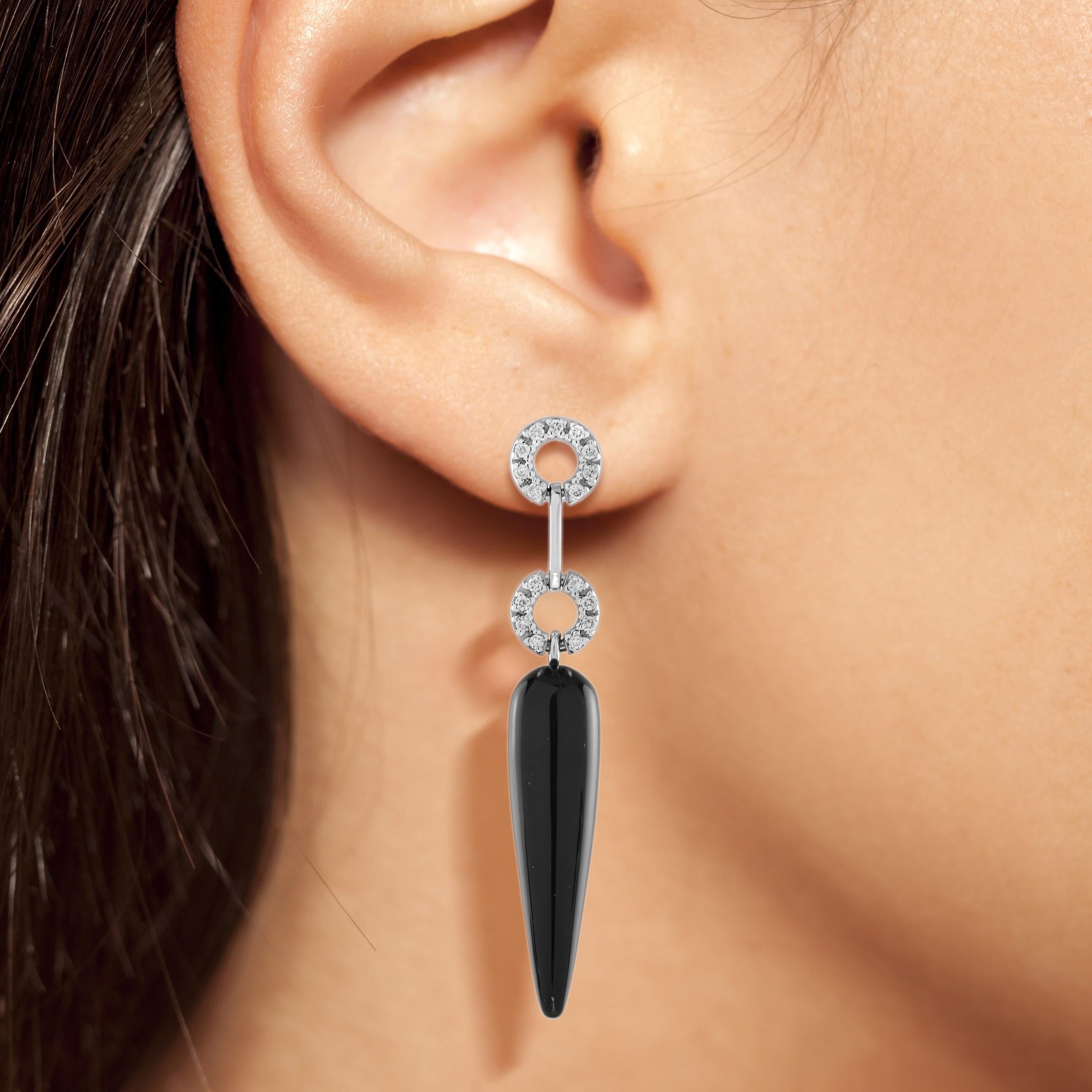 This beautiful pair of unique drop earrings are truly a statement making piece. Measuring about 41 mm. long, they are crafted in 14k white gold and are secured by a post and butterfly fitting. These earrings feature two chili shape pieces of black