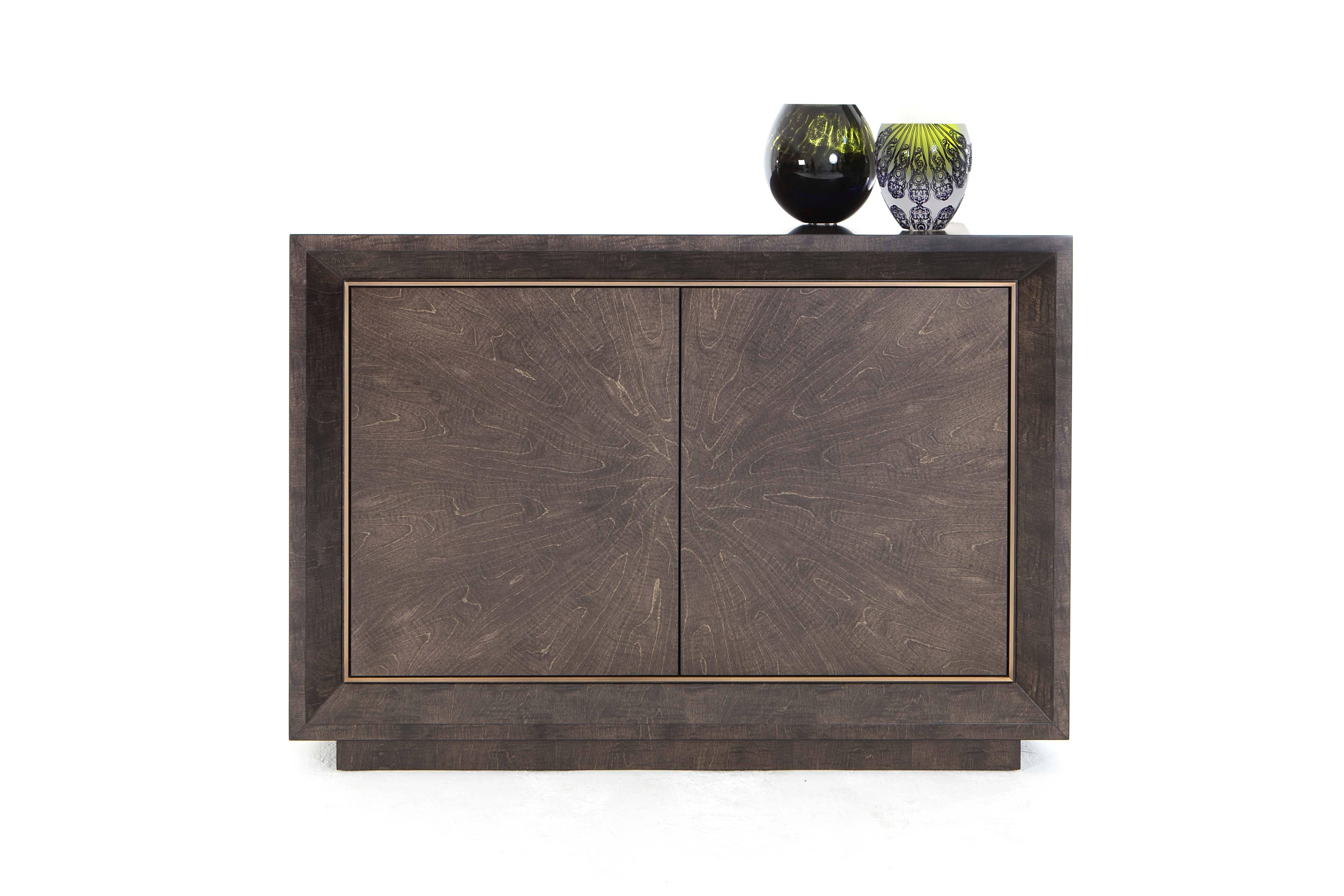 A striking side cabinet finished in satin sycamore grey and antiqued brushed brass.

Smart and refined storage with a luxurious bronze moulding opening to reveal an interior in matte sycamore grey with two adjustable shelves.

There is the option of