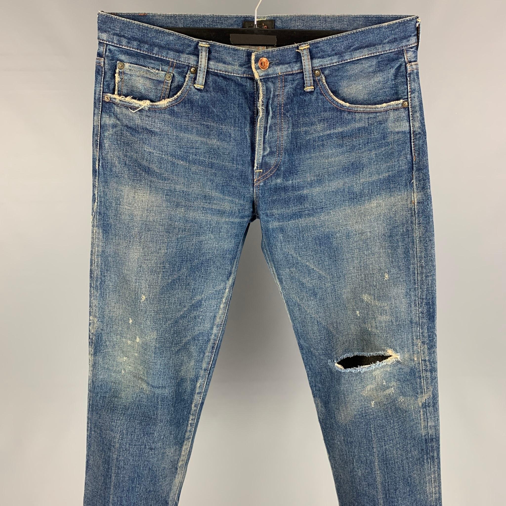 CHIMALA jeans comes in a indigo wash selvedge denim featuring a regular fit, distressed, raw edge, contrast stitching, and a button fly closure. Made in Japan. 

Good Pre-Owned Condition.
Marked: 31

Measurements:

Waist: 34 in.
Rise: 10.5