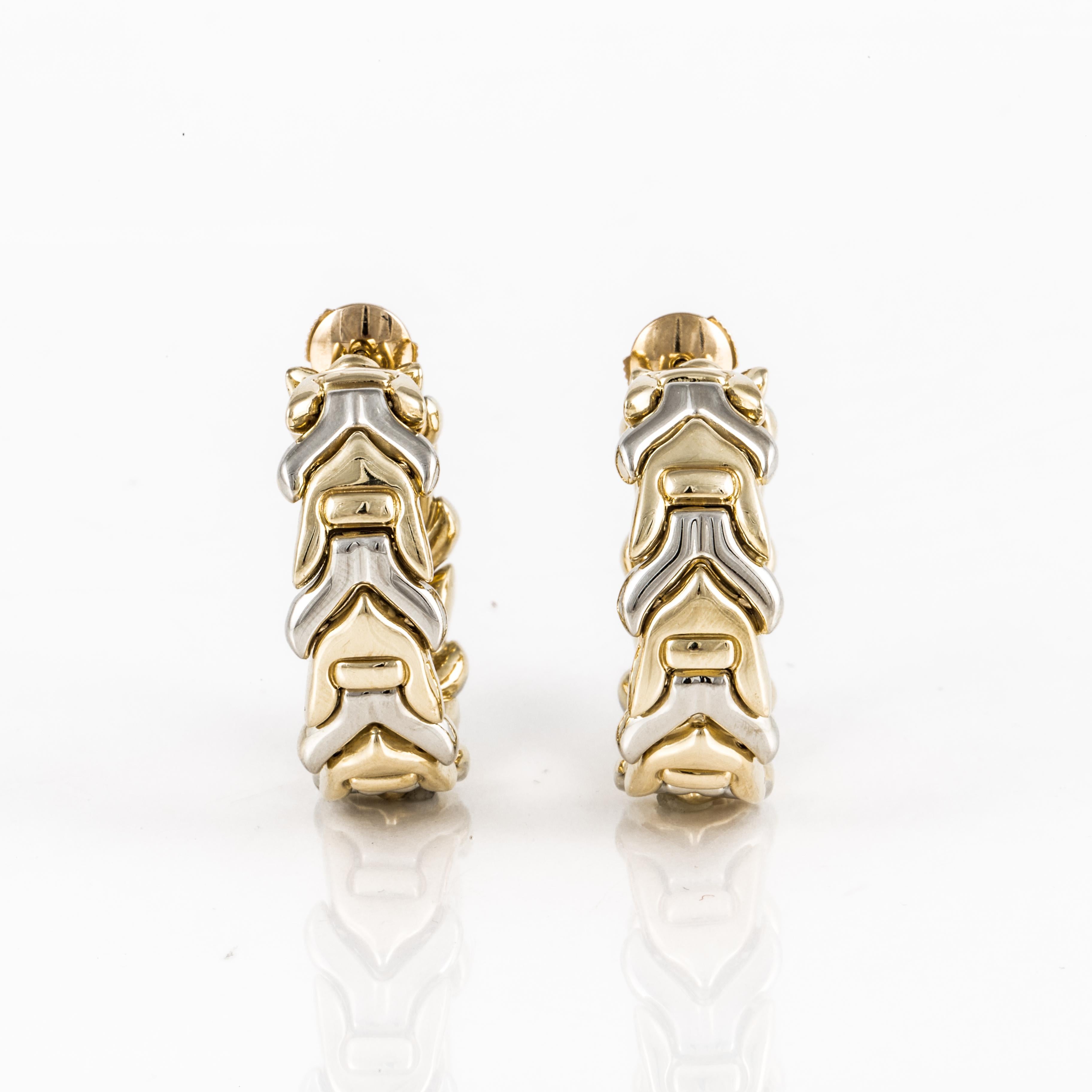 Chimento hoop style earrings in 18K white and yellow gold with a chevron pattern. They measure 1 1/16 inches long and 7/16 inches wide.  The closing mechanism is very secure with a post going through the backside of the earring and then a clutch.