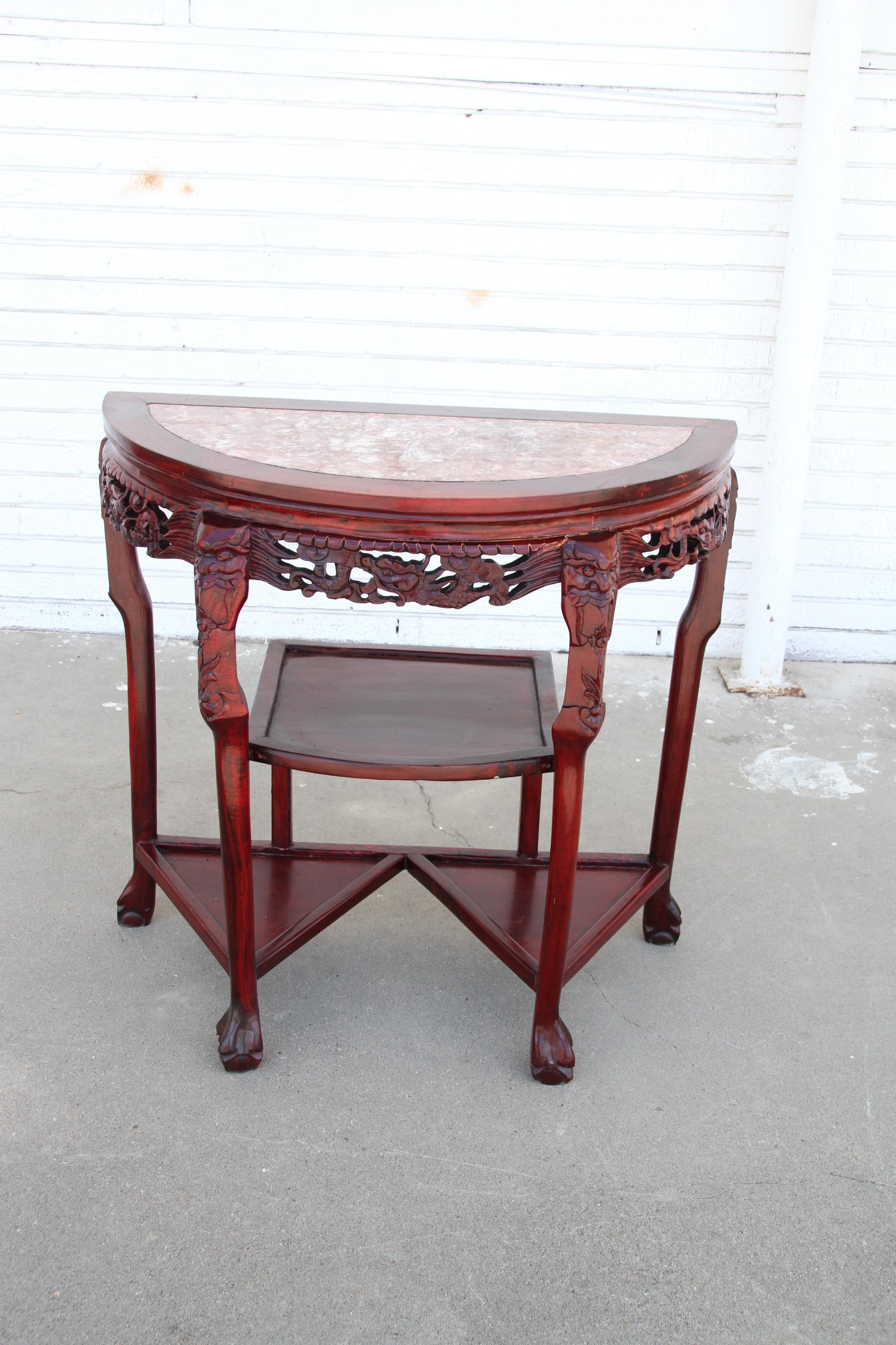 Chin Hua Marble Console 

Vintage Oriental Chinese carved hardwood demilune marble top console table. Item features a half round demilune top with inset pink marble, carved ball and feet and multiple tiers.

Measurements: 32